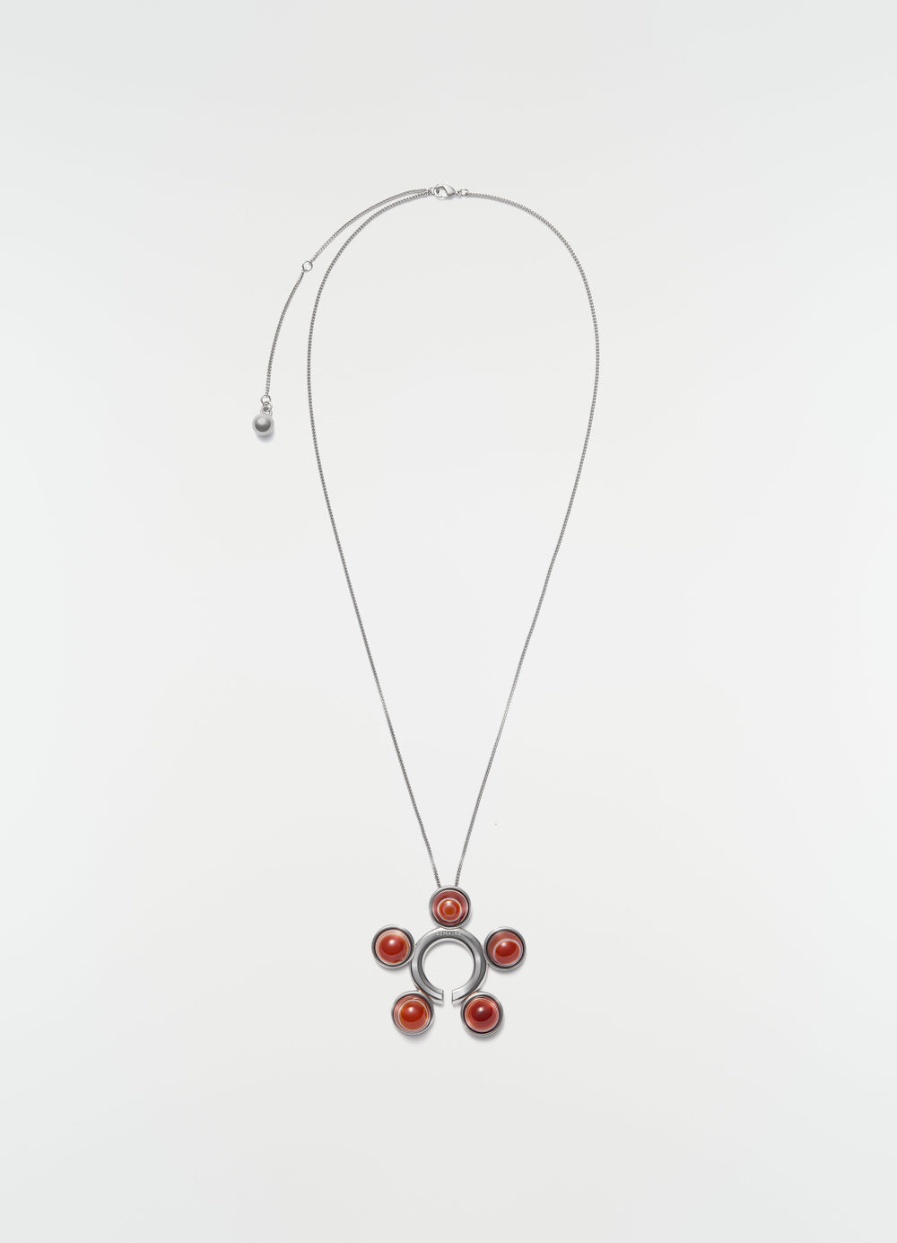 Garment ornament and necklace in silver brass with red stones by LEMAIRE on plain white background