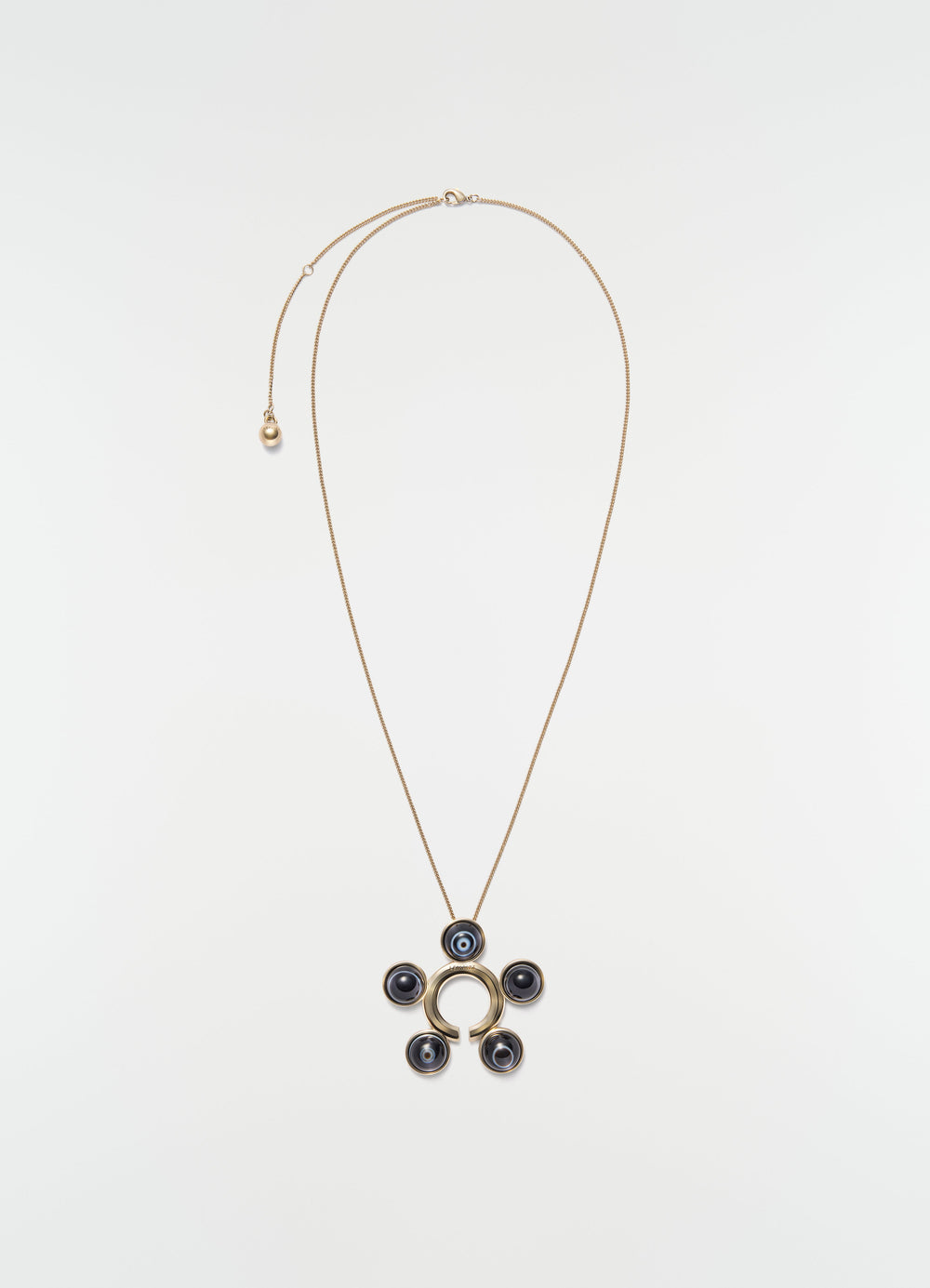 Garment ornament and necklace in brass with black stone circles by LEMAIRE on plain white background