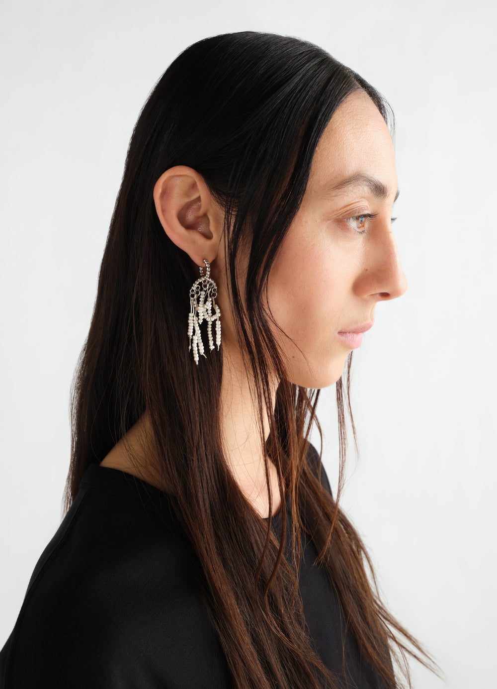 Short glass bead tassel silver earrings LEMAIRE worn by model side profile on white background