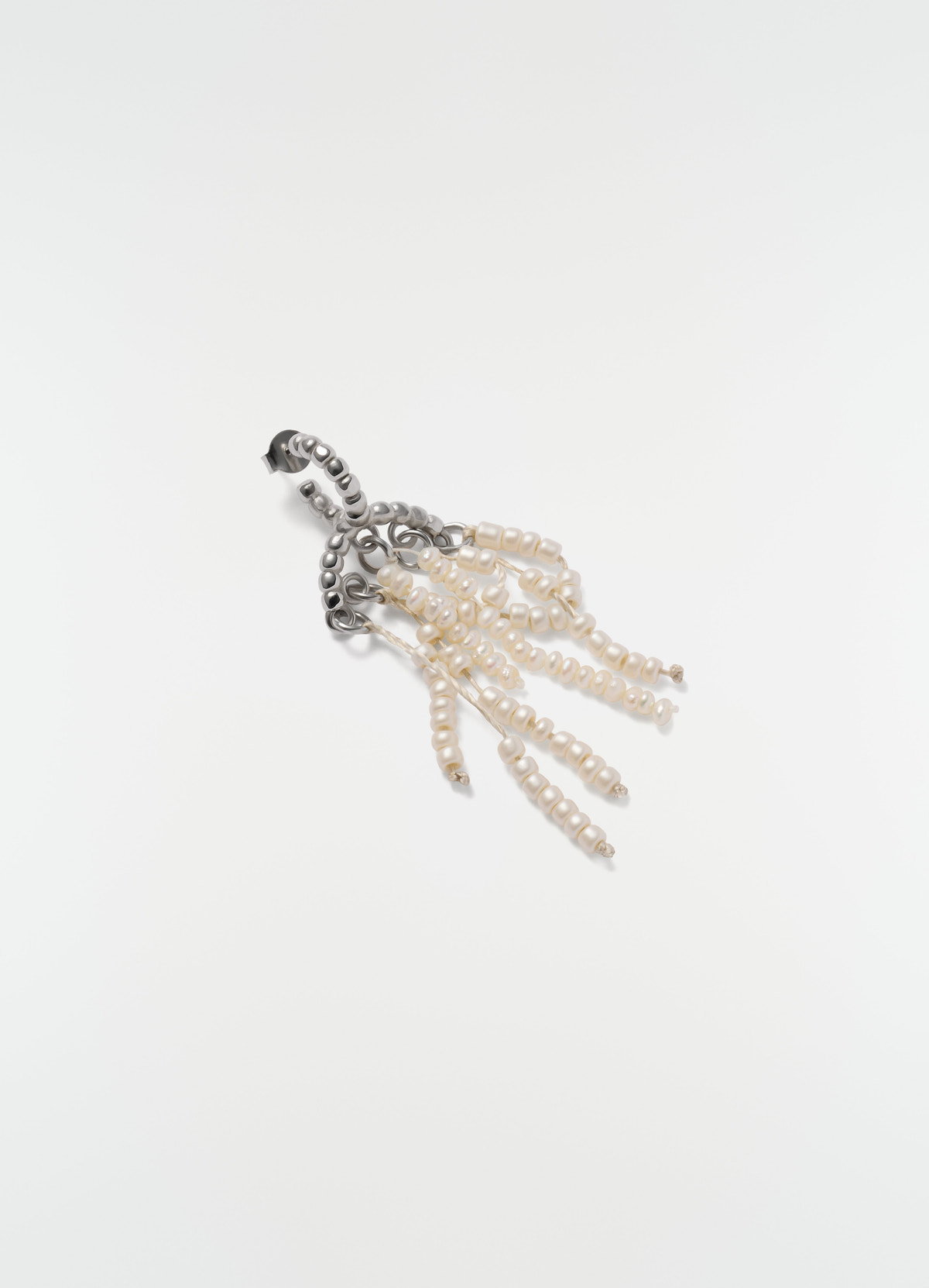 Short glass bead tassel earrings in silver and white by lemaire on plain white background close-up detail