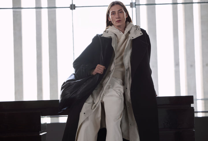 Long black coat in Black wool, cream cotton, model shot, Front view Layered, relaxed fit