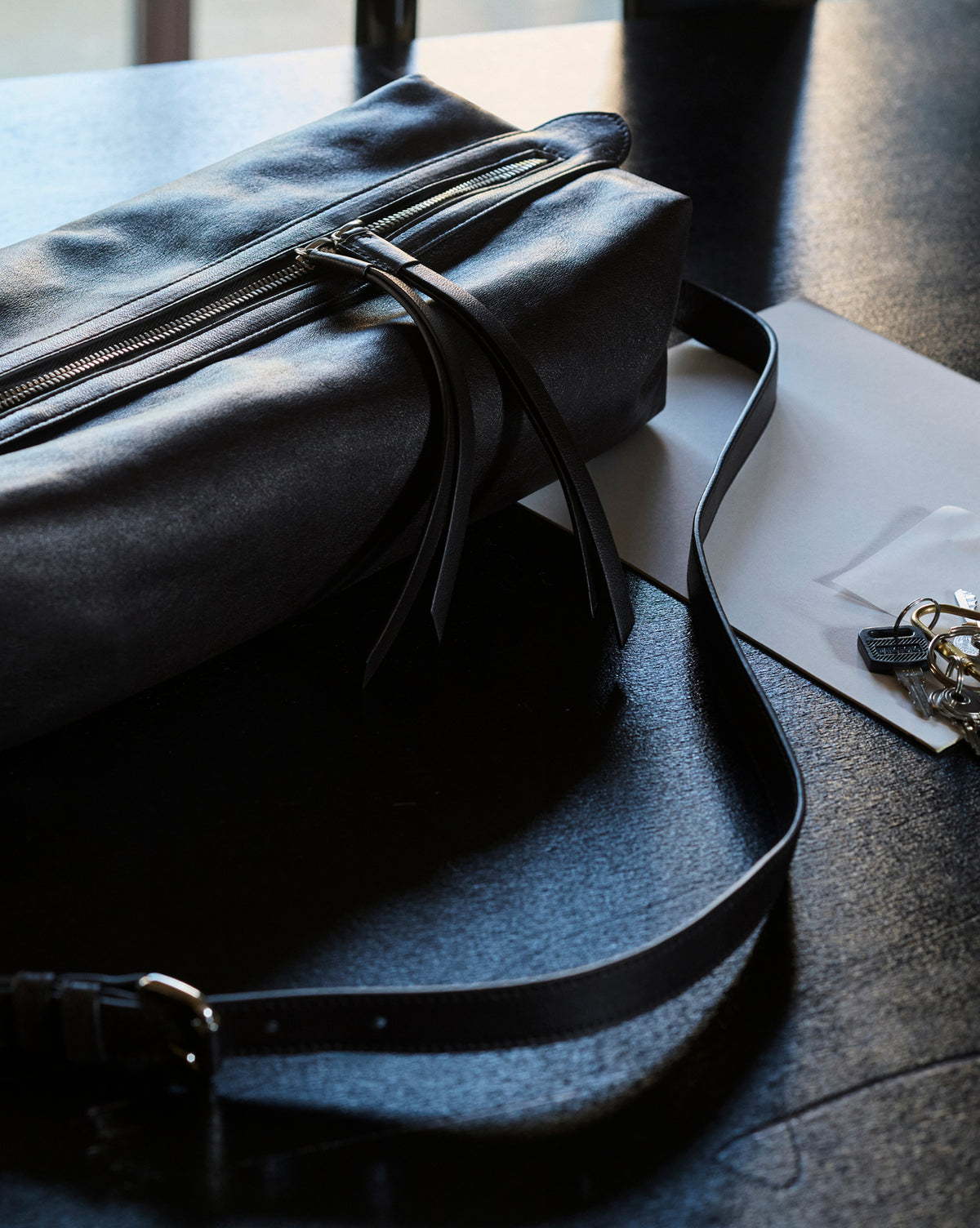 Small black nappa lambskin Care Bag with silver zipper and adjustable strap by LEMAIRE on plain white background