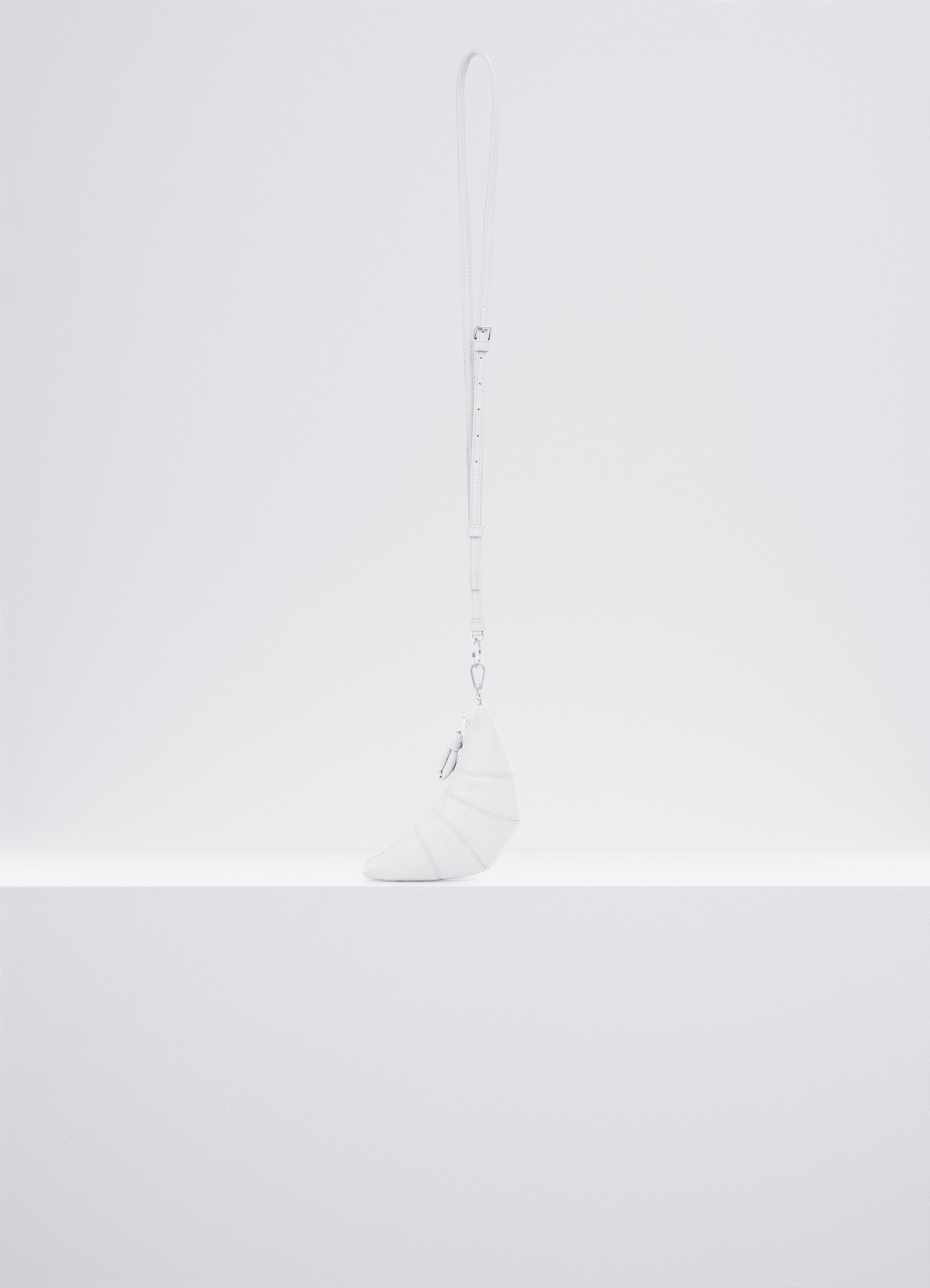 Cross-body croissant coin purse in soft grained leather, product shot, side view topstitched cutouts