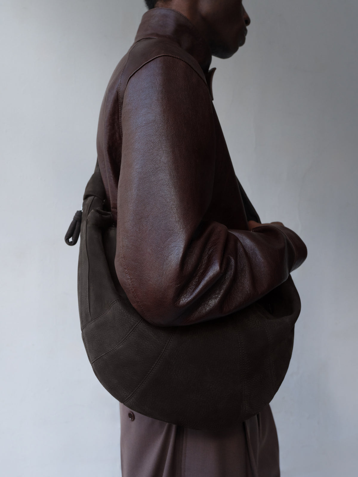 Medium brown nubuck leather croissant bag with knotted strap LEMAIRE front on white background