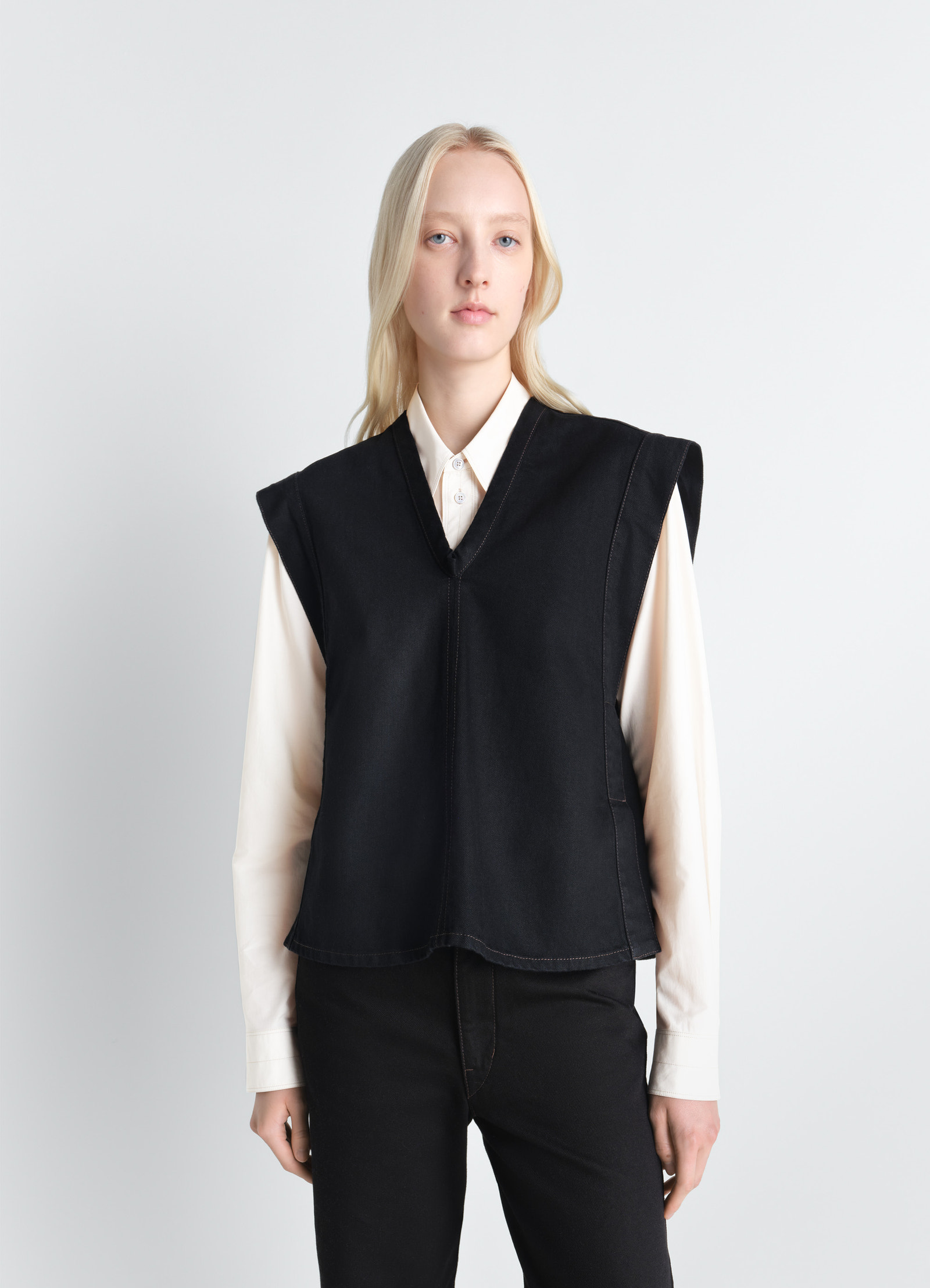 Lemaire chasuble in deep black denim, model shot, close-up front view structured shoulders