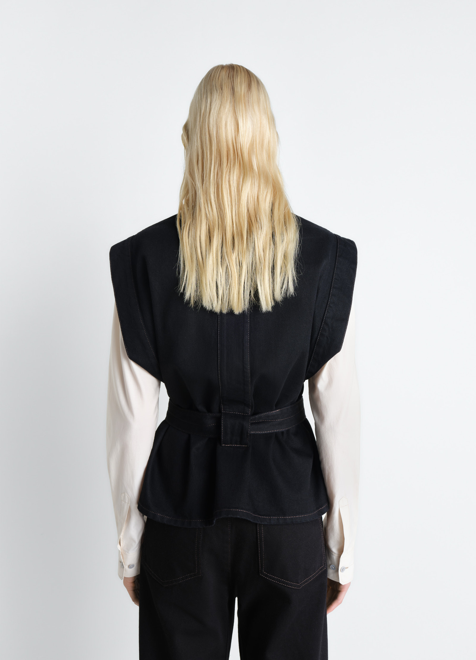 Lemaire chasuble in deep black denim, model shot, back view back pleat detail