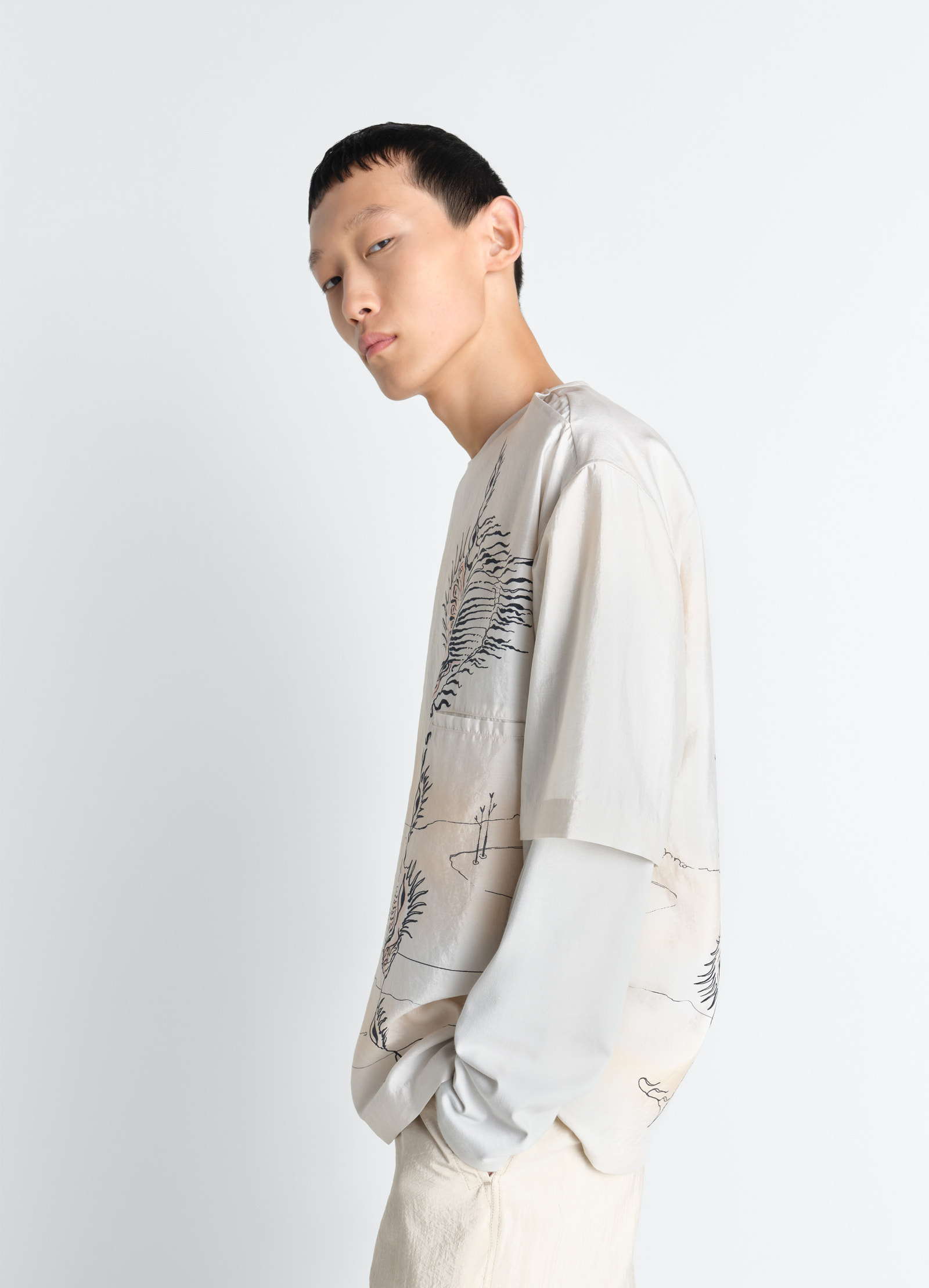 Button neck top in shell printed silk, model shot, three-quarter side view asymmetrical hem
