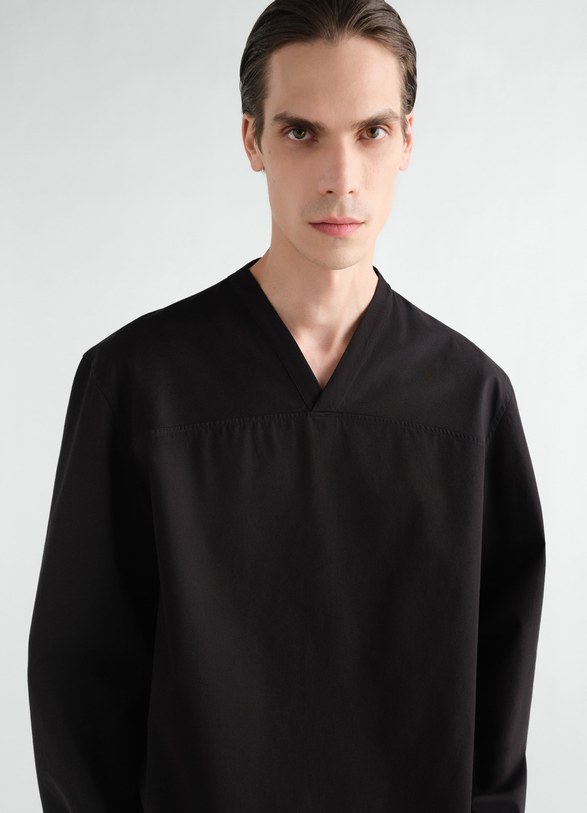 Top à encolure v en twill de coton léger, coloris noir, porté par un mannequin, gros plan de face, manches visibles