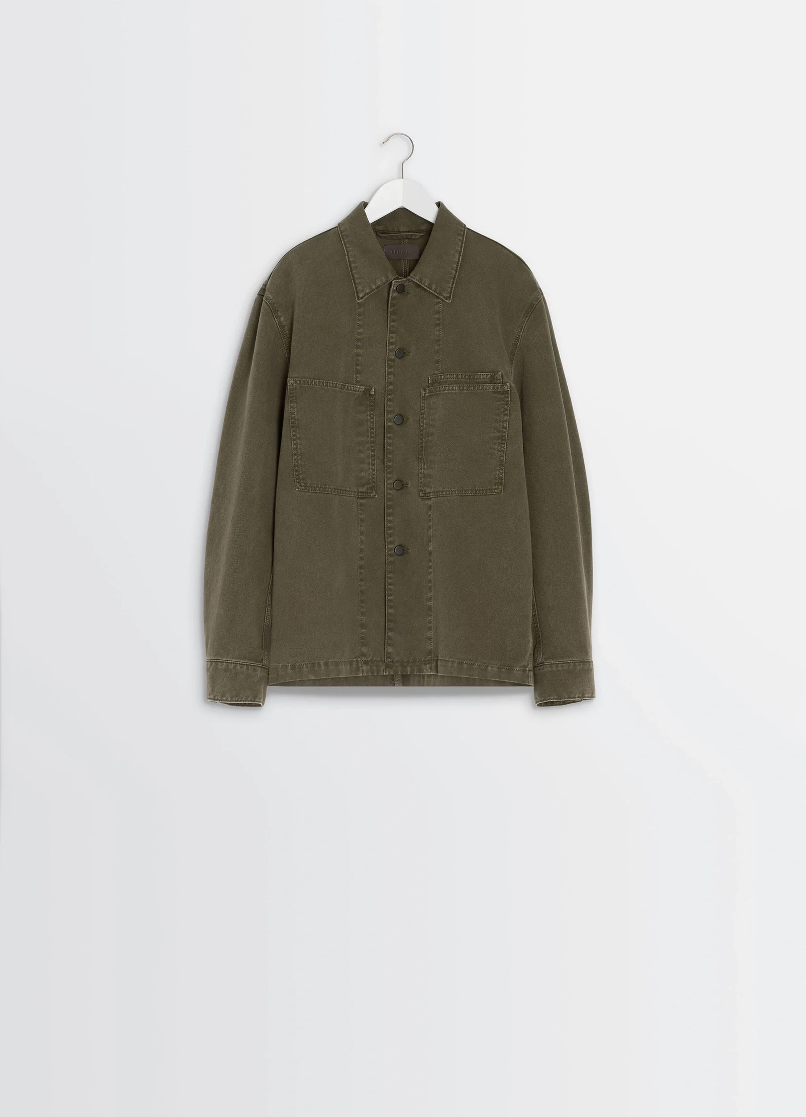 Lemaire workwear overshirt in garment dyed snowy denim, product shot, hanger front view structured shoulders, clean seams