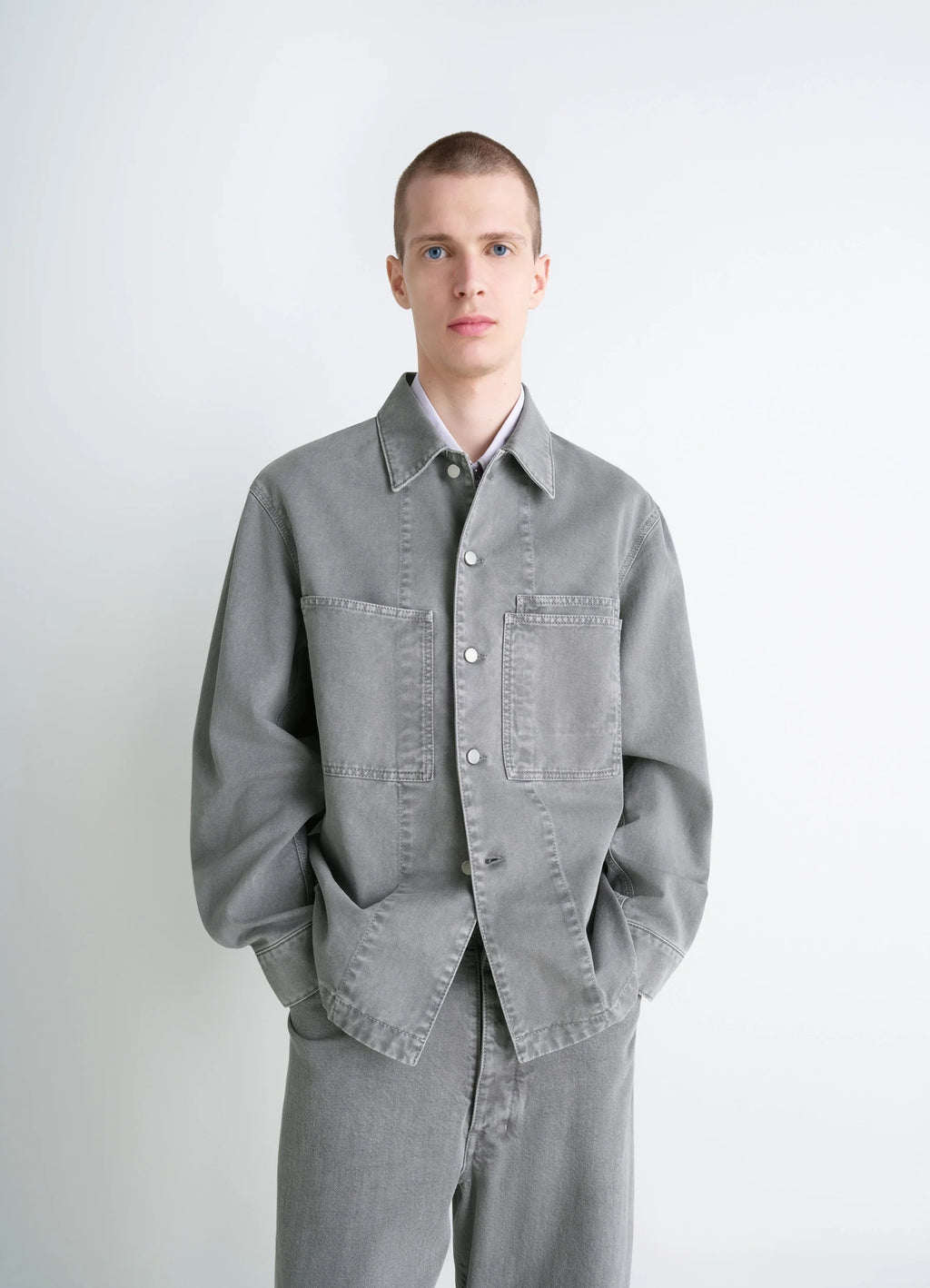 Lemaire Workwear Overshirt in Garment Dyed Snow Medium Denim, model shot, front view loose fit, dual chest pockets