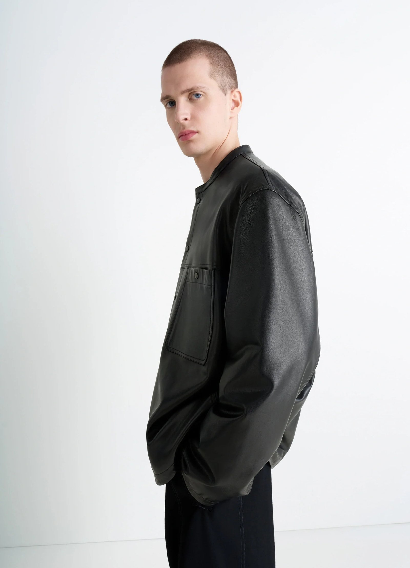 Leather collarstand overshirt in nappa lamb leather, model shot, profile side view minimalist shoulder seam