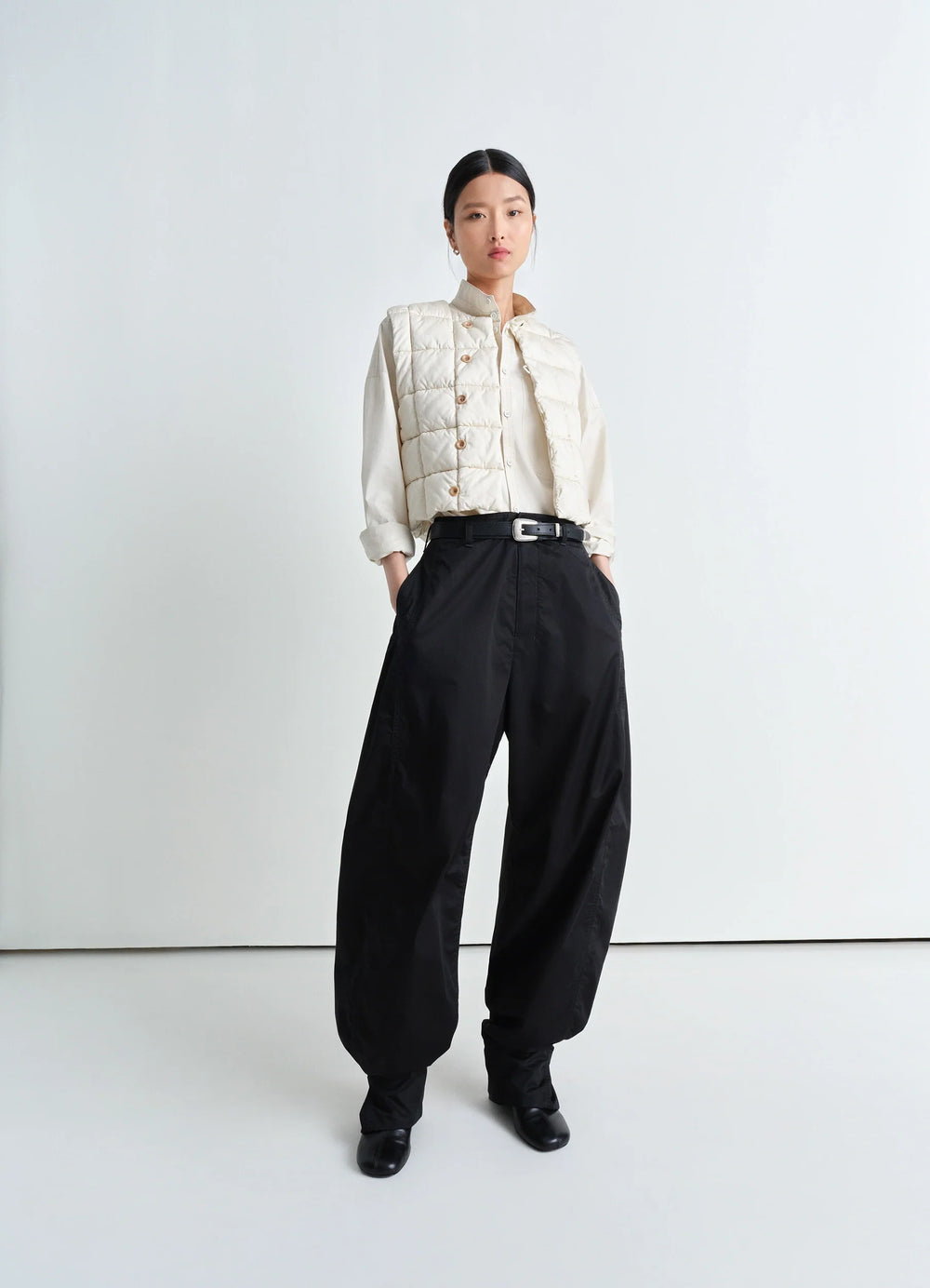 Lemaire Wadded Gilet in Light Cotton Satin, model shot, three-quarter view boxy fit, styled unbuttoned