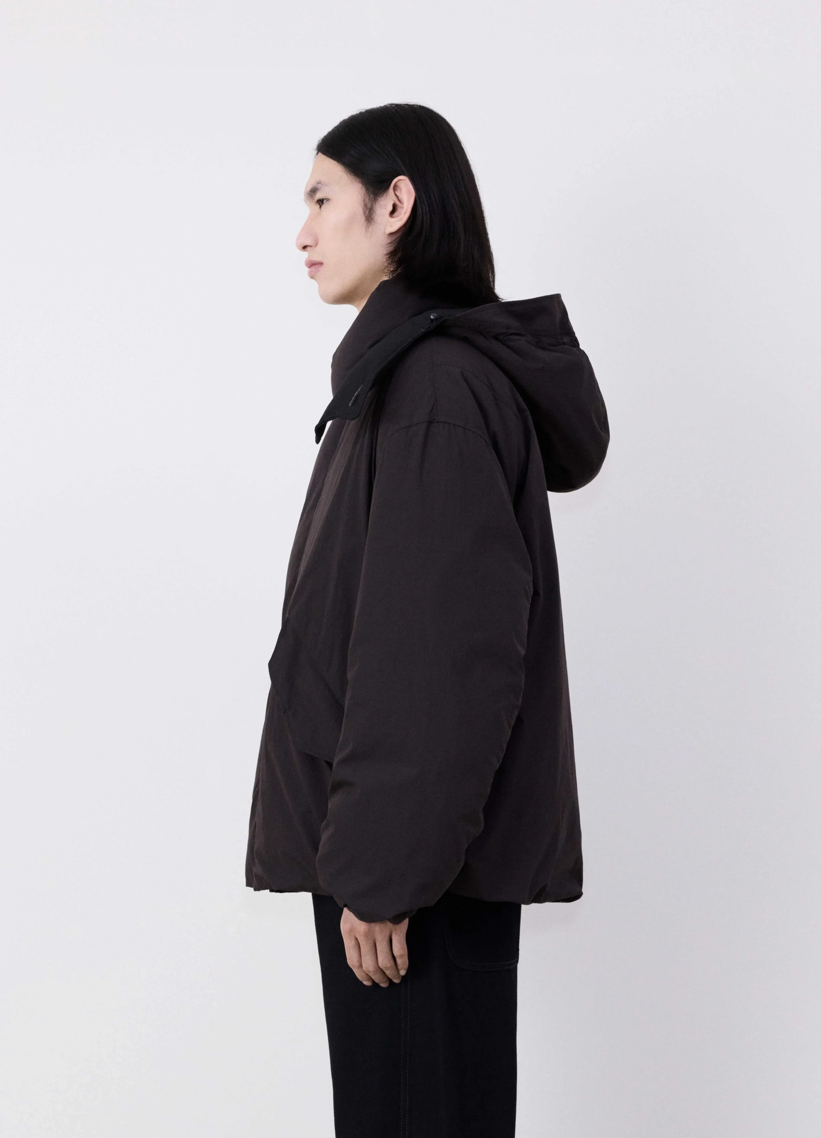 Lemaire hooded puffer blouson in dark cotton blend, model shot, side profile view loose fit hemline
