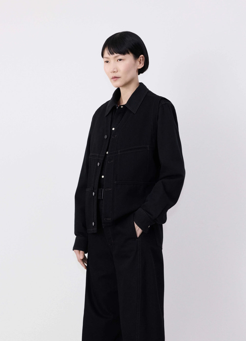 Lemaire Sleeveless Gilet in Deep Black Denim, model shot, Side view Straight fit, V-neck