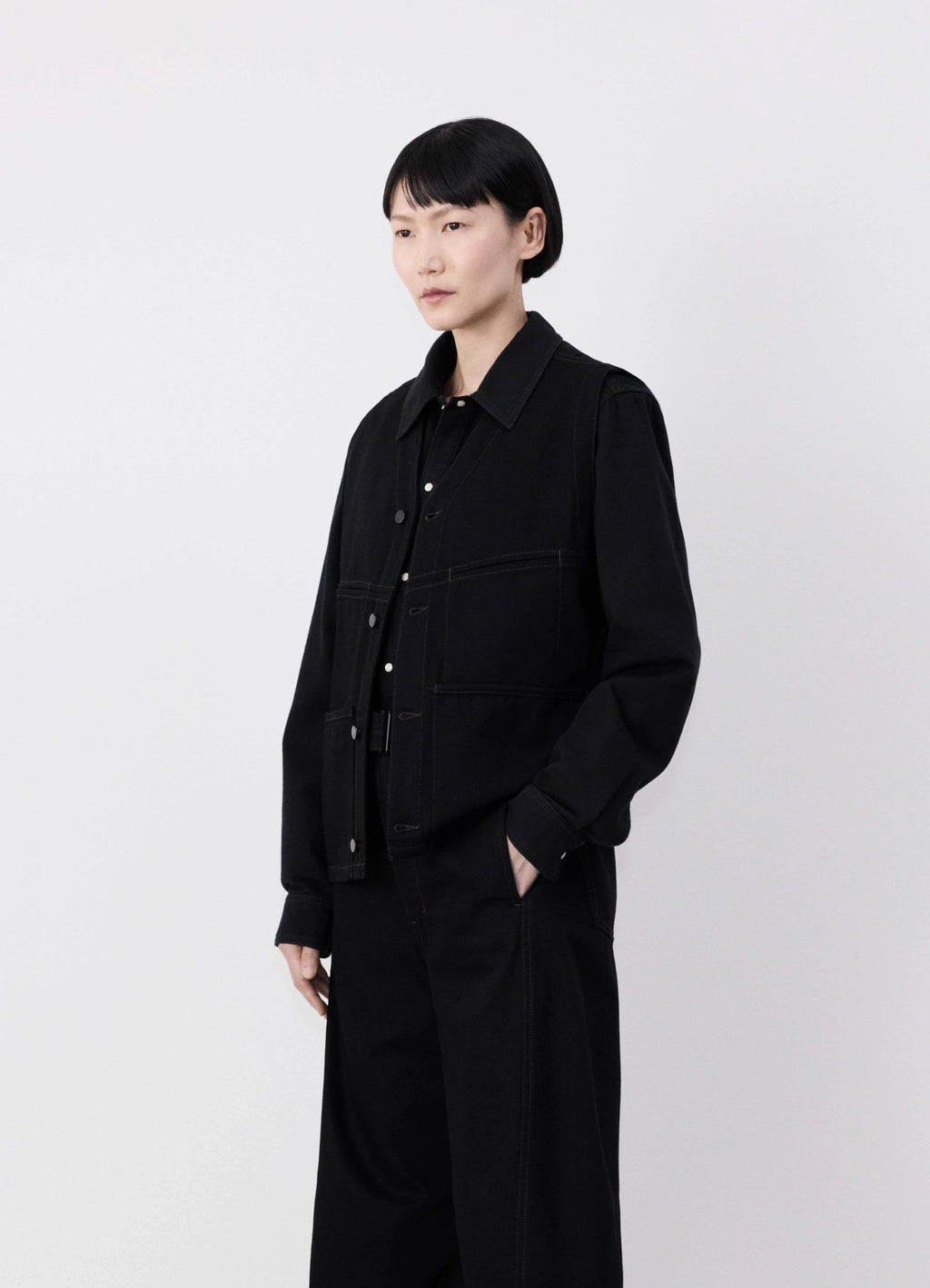 Lemaire Sleeveless Gilet in Deep Black Denim, model shot, Side view Straight fit, V-neck