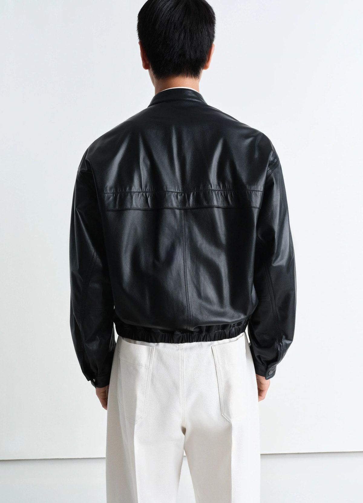 Soft boxy blouson in black lamb leather, model shot, back view elastic hem detail