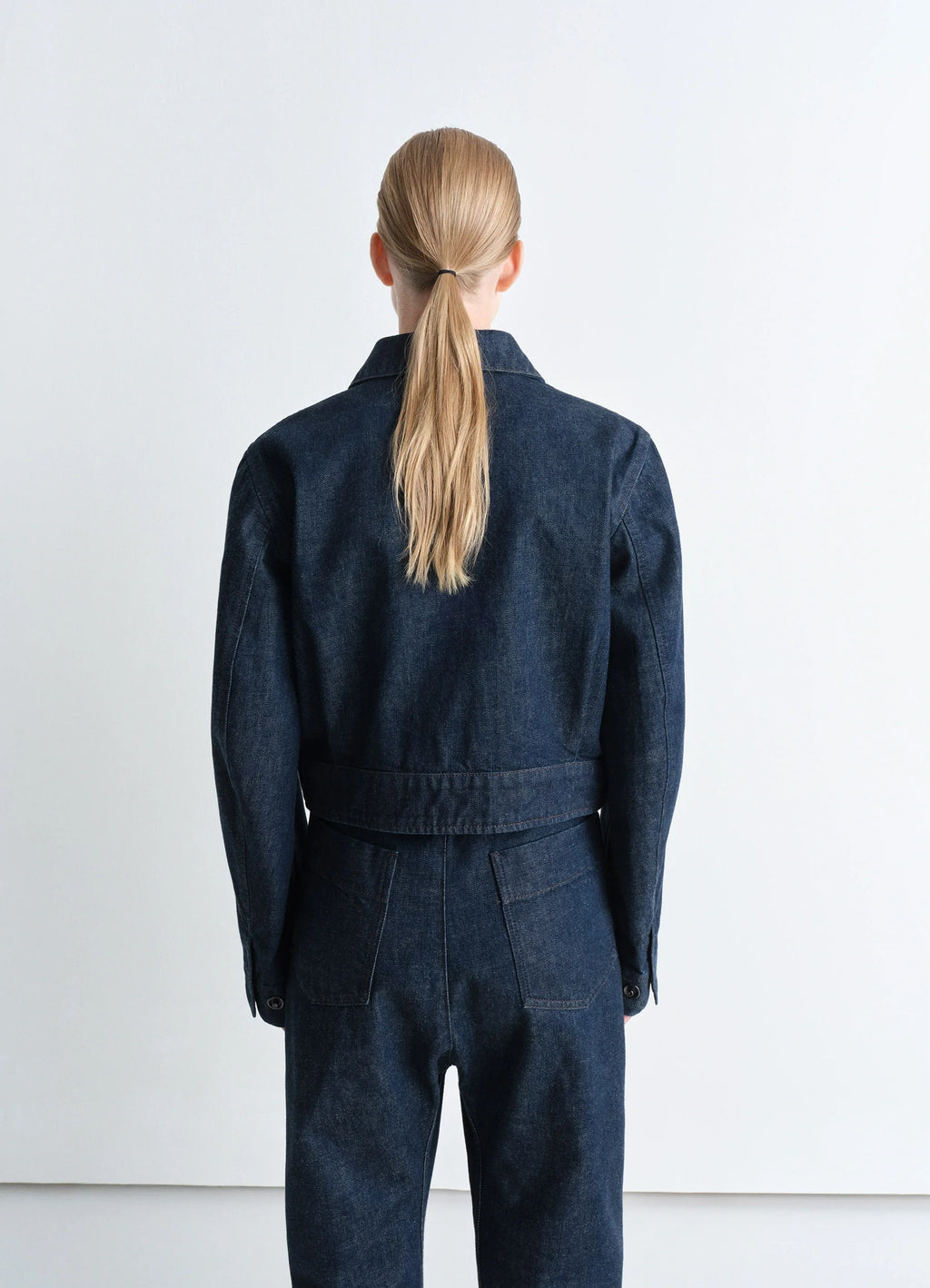 Lemaire Two Pocket Cropped Jacket in Deep Indigo Heavy Denim, model shot, back view buttoned cuffs