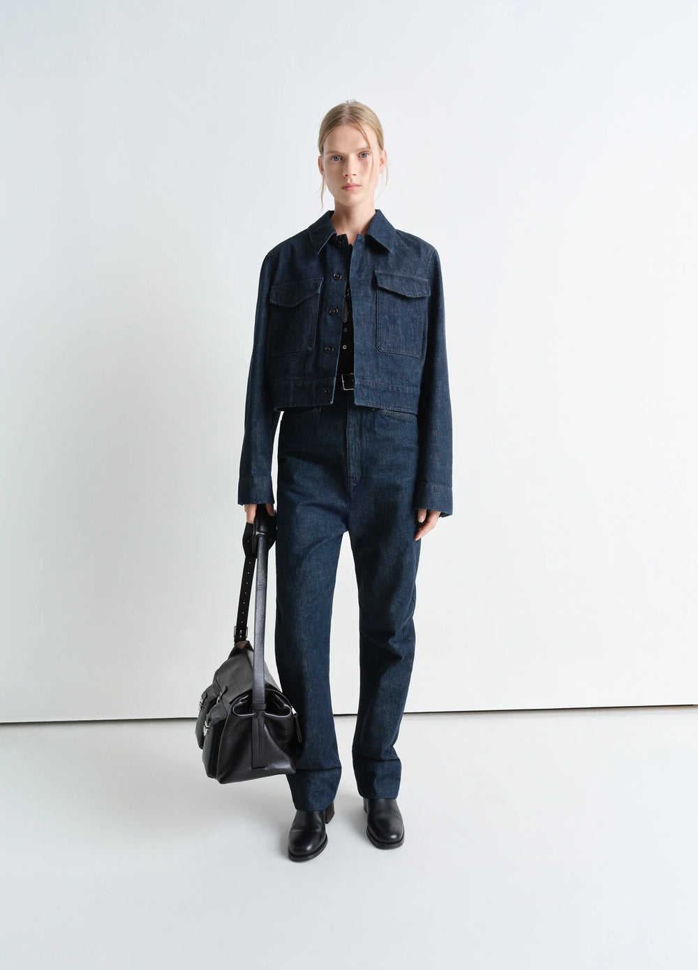 Lemaire Two Pocket Cropped Jacket in Deep Indigo Heavy Denim, model shot, three-quarter view worn with straight leg pants