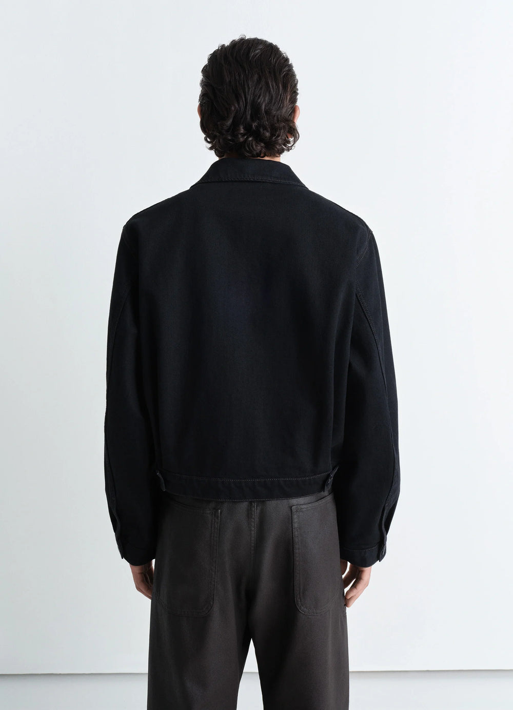 Lemaire Trucker Jacket in Deep Black Heavy Denim, model shot, back view dropped shoulders