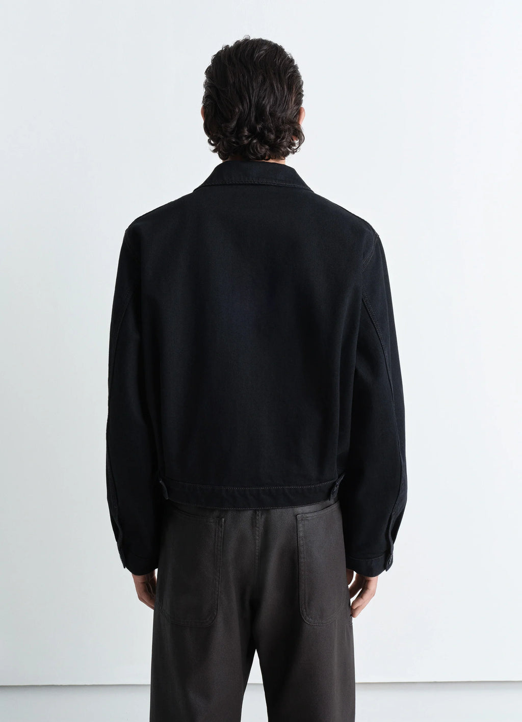 Lemaire Trucker Jacket in Deep Black Heavy Denim, model shot, back view dropped shoulders