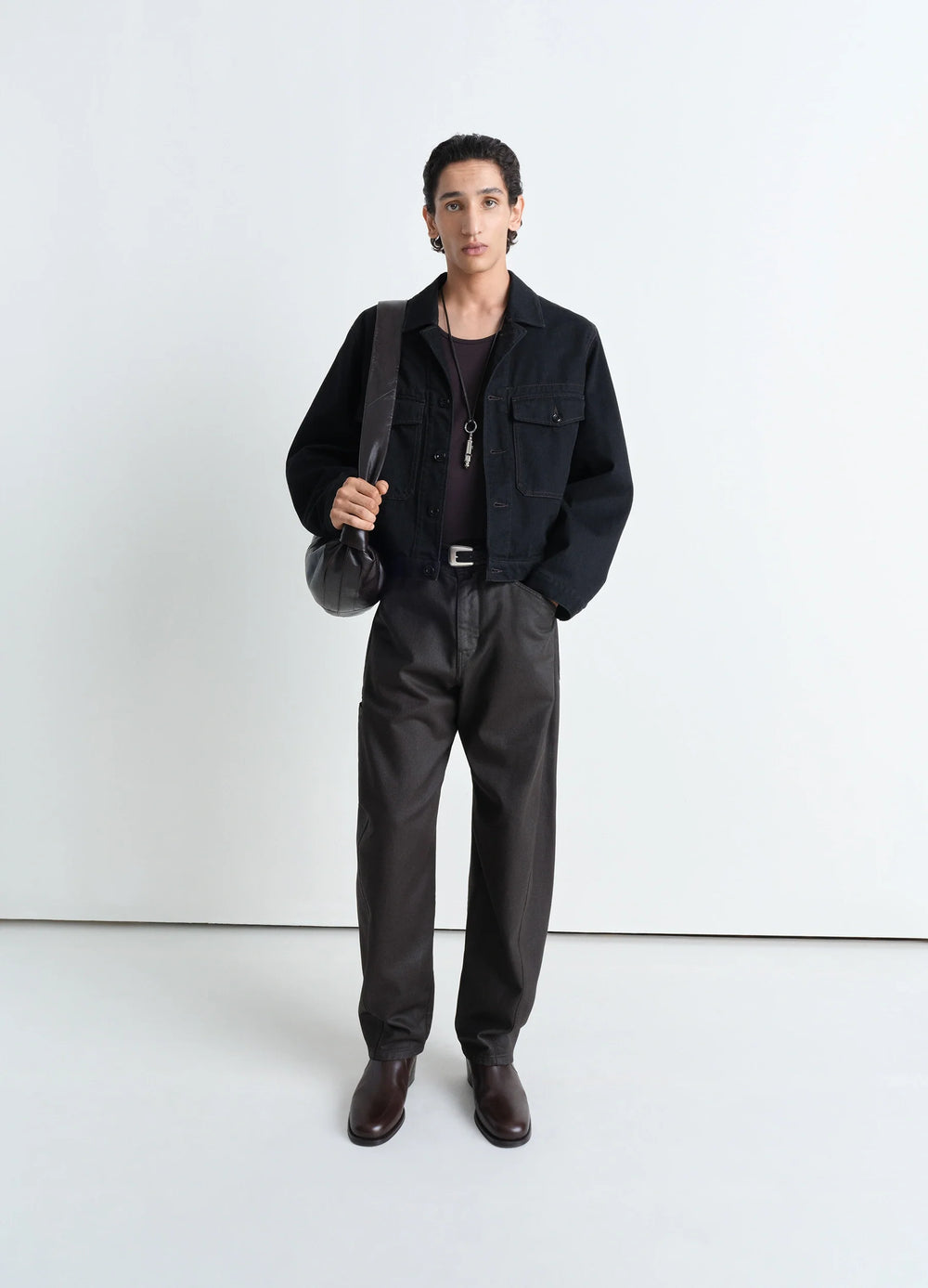 Lemaire Trucker Jacket in Deep Black Heavy Denim, model shot, full body front view worn over black top