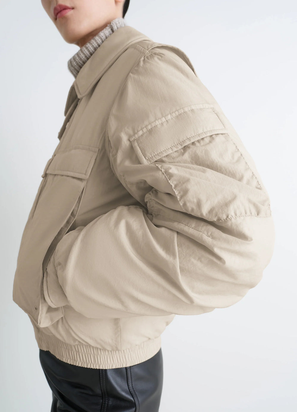 Lemaire Short Bomber in Beige Lightweight Nylon, model shot, back perspective elastic hem, arm detail