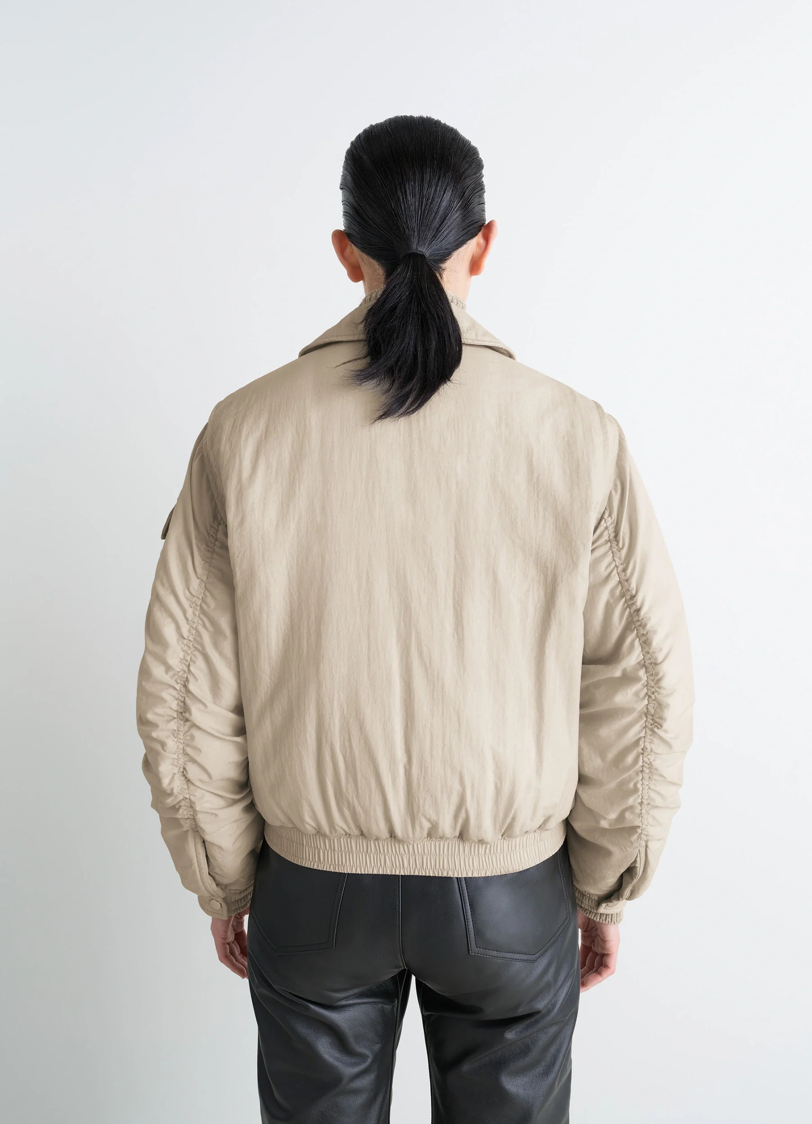 Lemaire short bomber in beige lightweight nylon, model shot, back view elastic hem