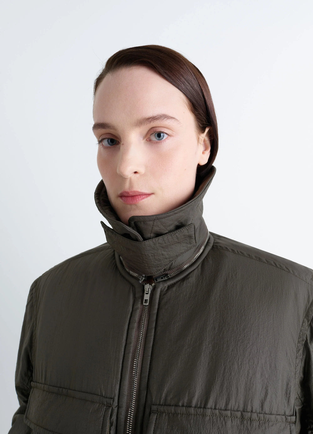 Lemaire Short Bomber in Olive Water-Repellent Nylon, model shot, close-up side view high collar detail visible