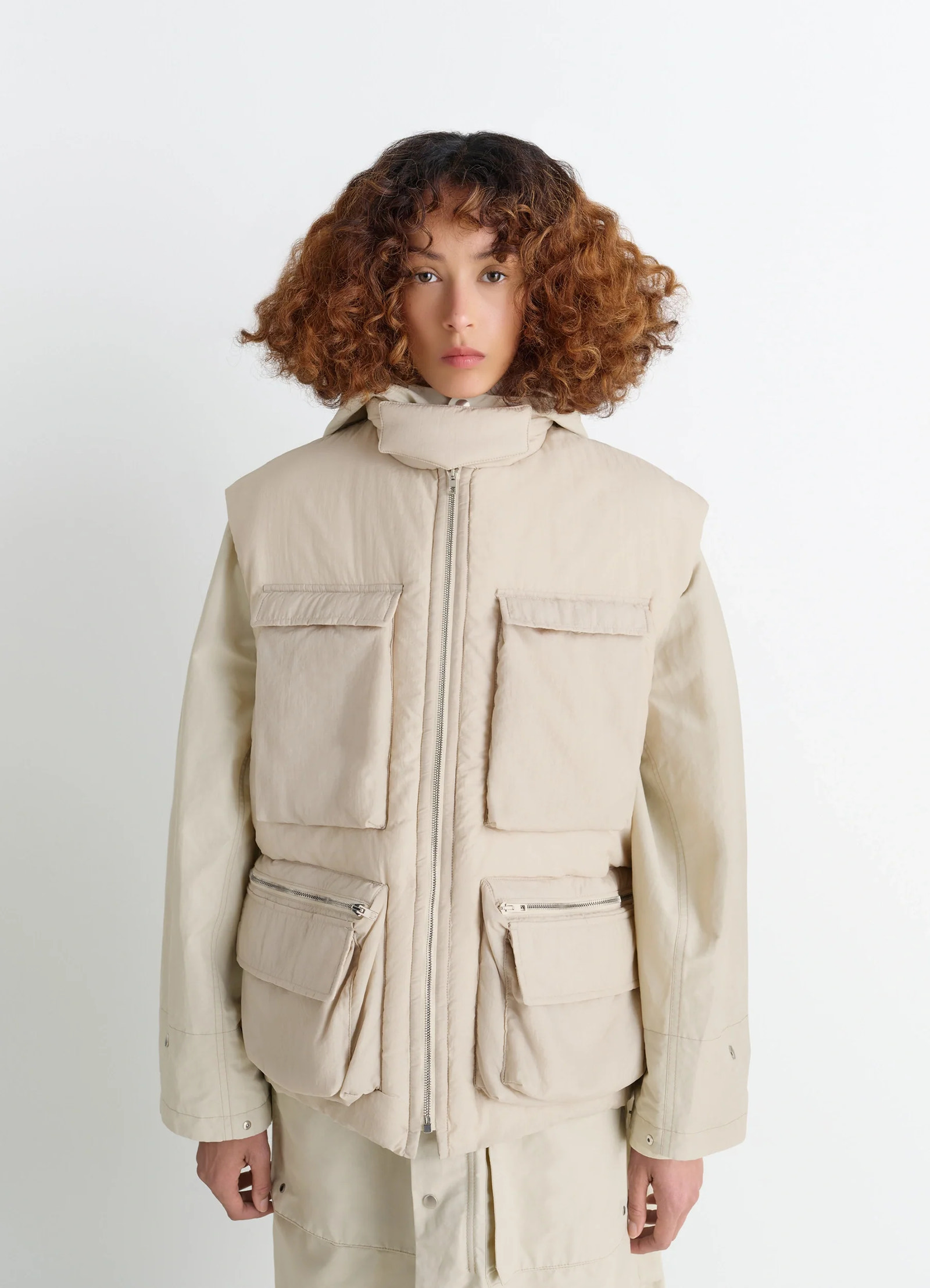Lemaire wadded gilet with pockets in beige water-repellent nylon, model shot, front view gusseted pockets, snap flaps