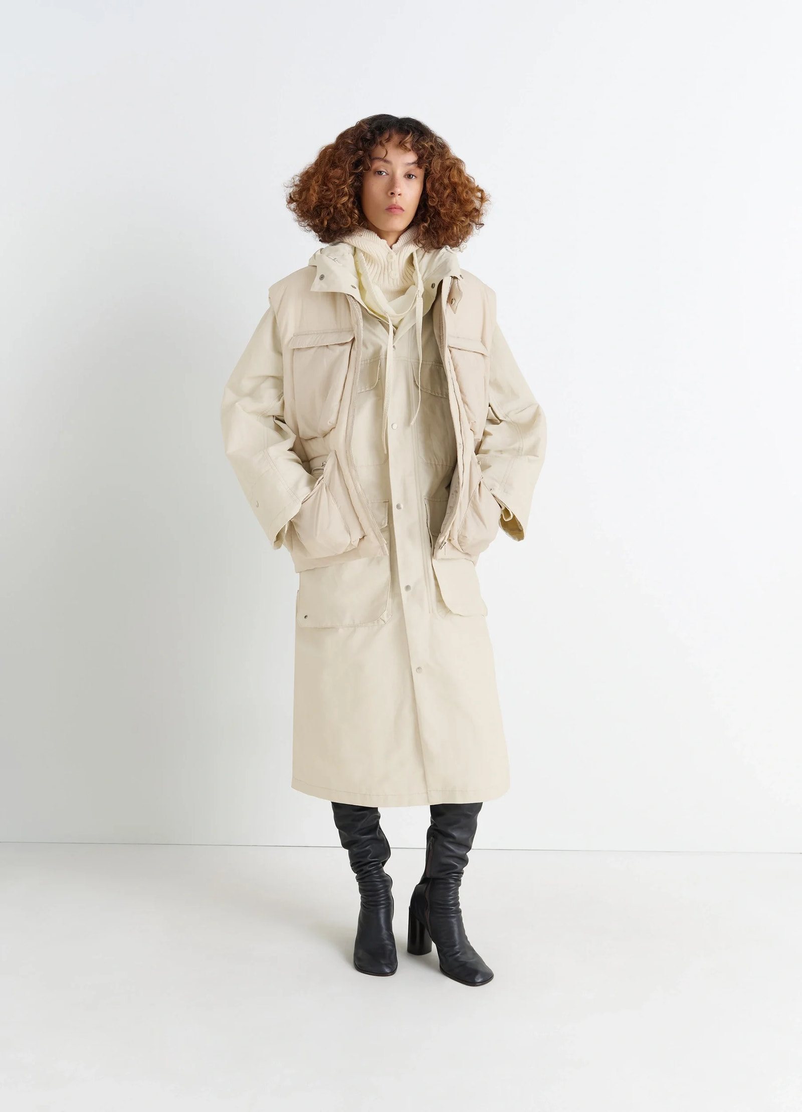 Lemaire wadded gilet with pockets in beige water-repellent nylon, model shot, full-body porte view layered with long coat