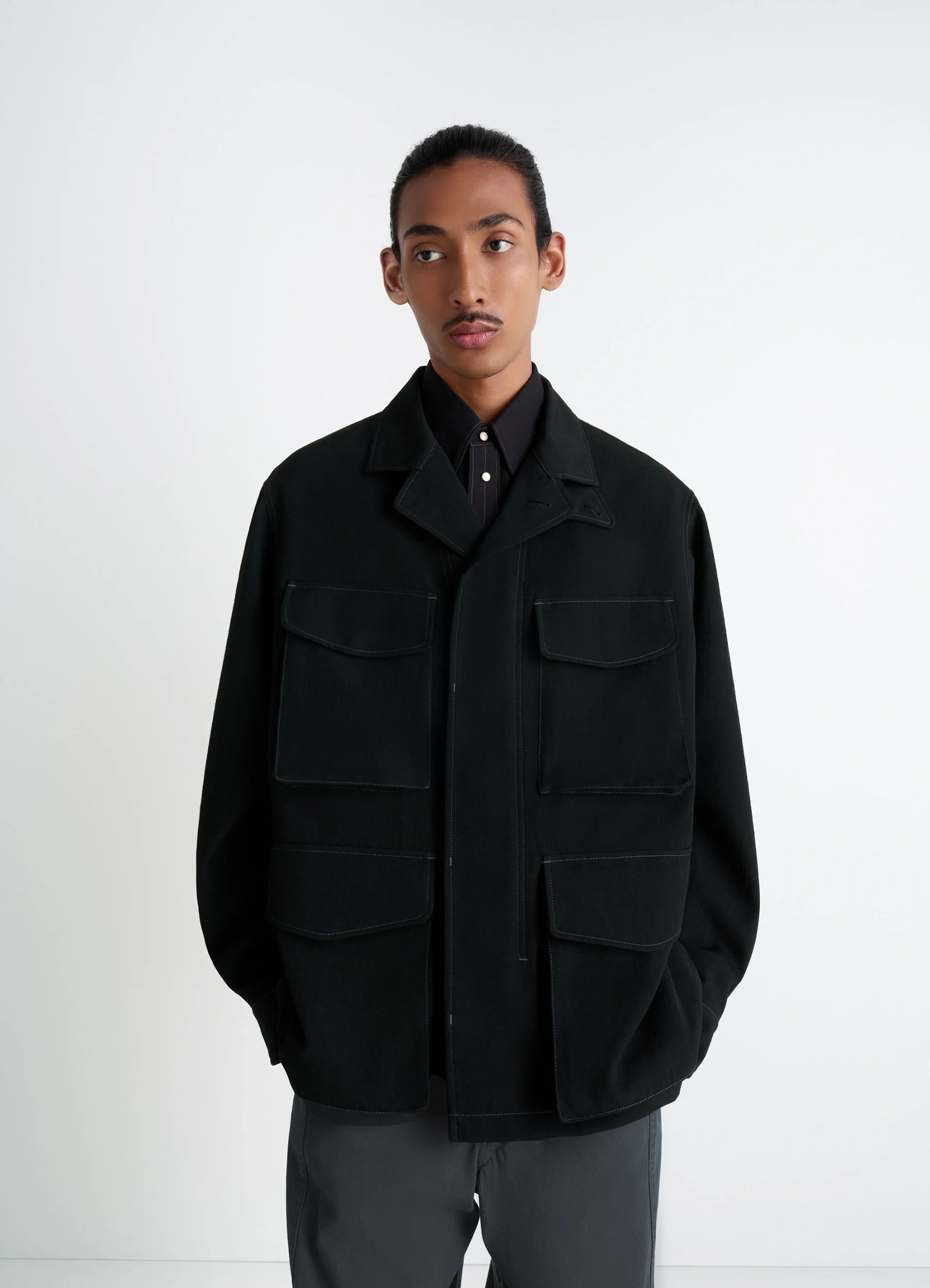 Soft field jacket in black wool twill, model shot, front view utilitarian pockets