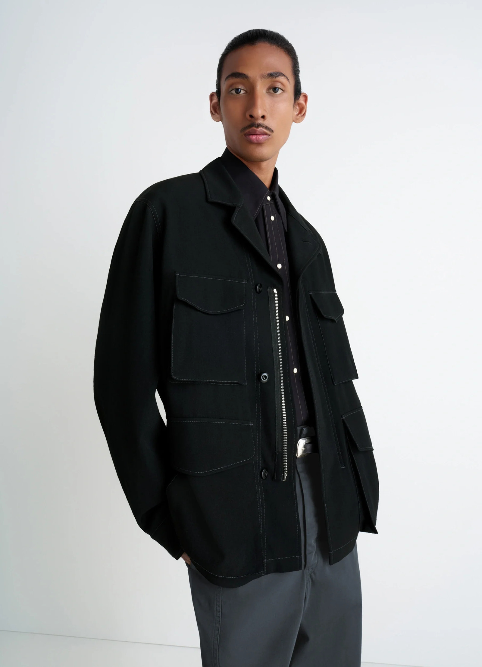 Soft field jacket in black wool twill, model shot, three-quarter view side pockets, relaxed fit