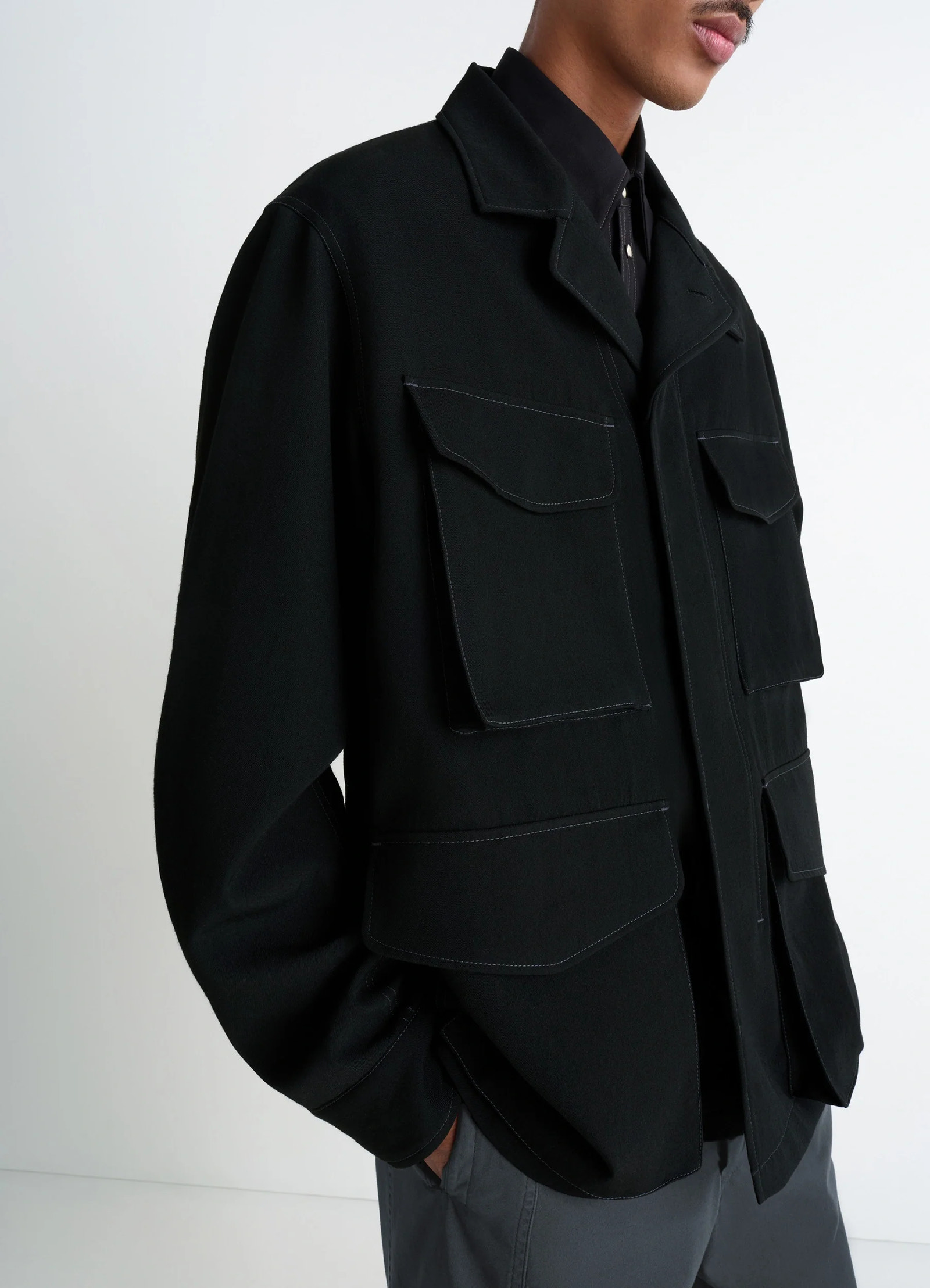 Soft field jacket in black wool twill, model shot, side detail shot large flap pockets