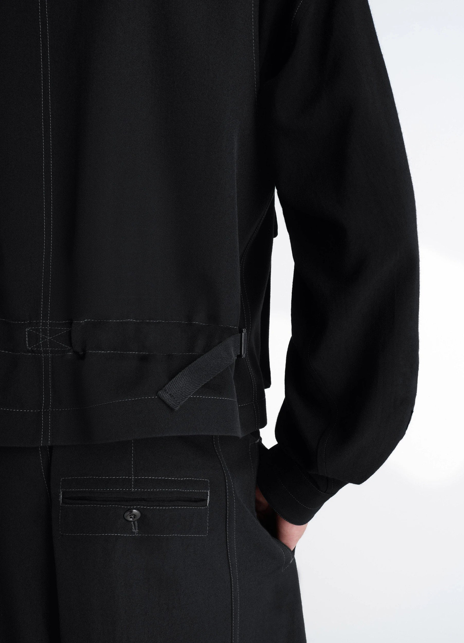 Utility gilet in light wool twill, model shot, back side view adjustable waist strap
