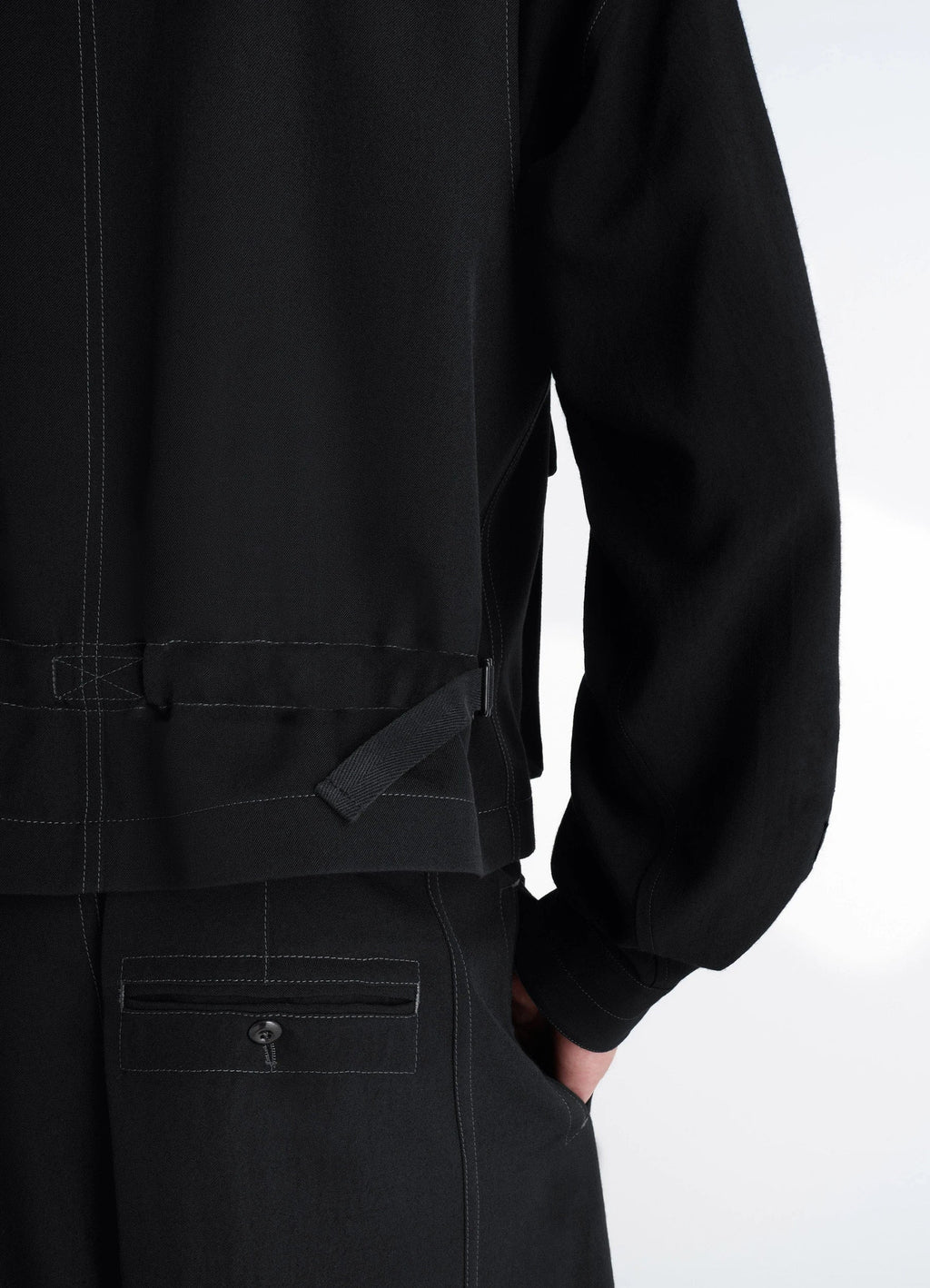 UTILITY GILET in light wool twill, model shot, back side view adjustable waist strap