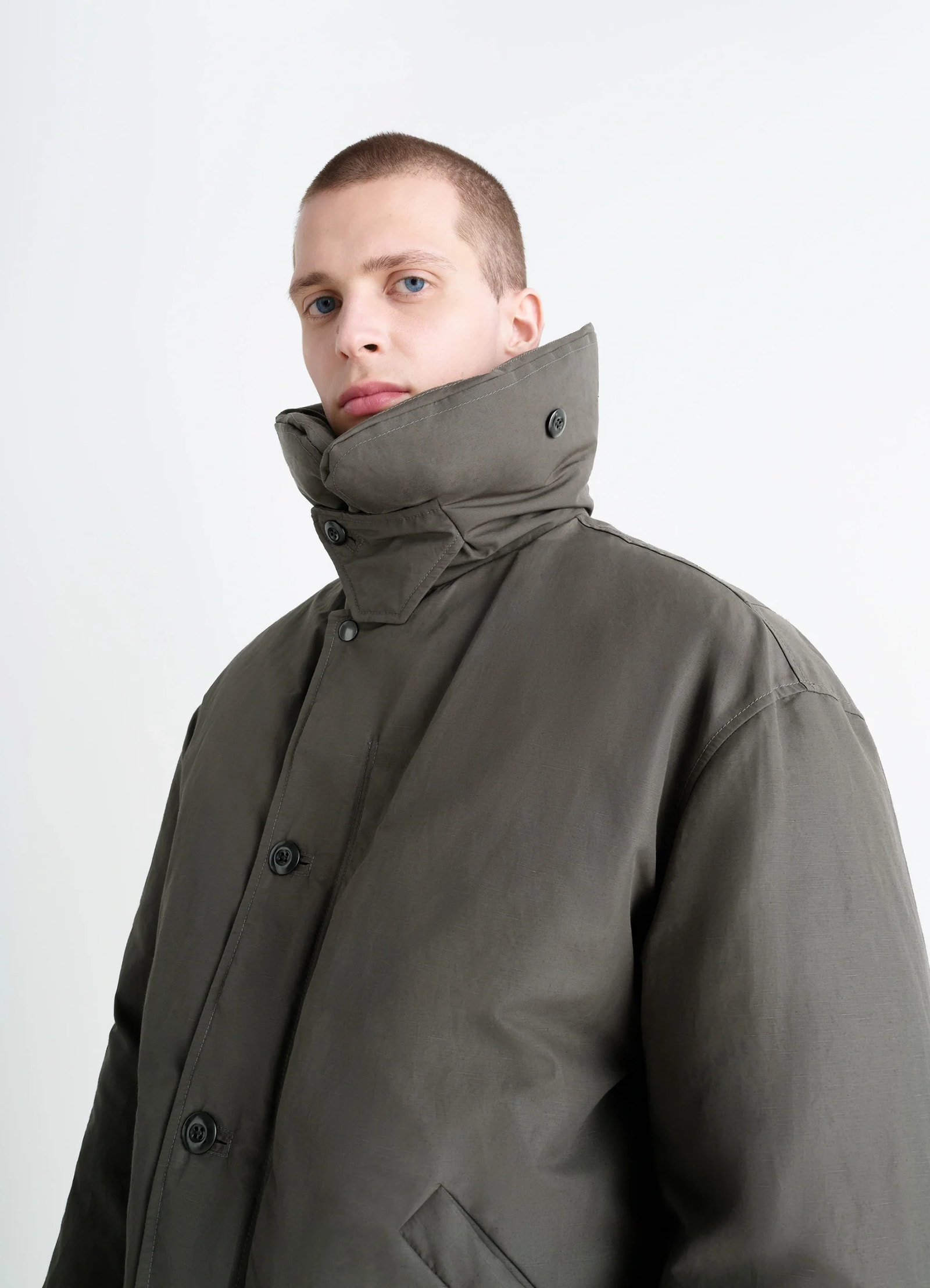 Puffer blouson in olive linen cotton, model shot, close-up side view high collar button detail