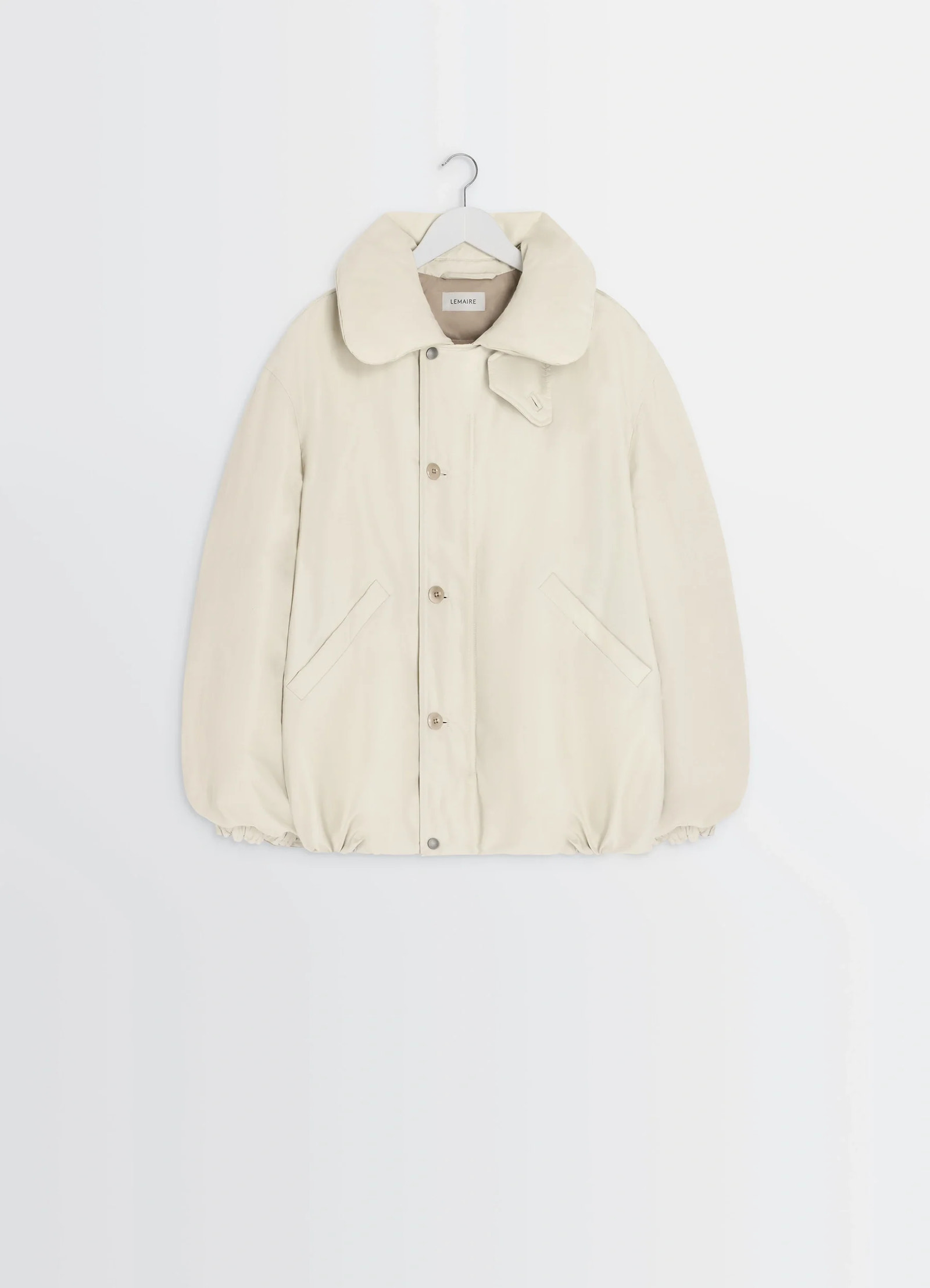 Puffer blouson in light beige linen cotton, product shot, hanger front view elastic hem detail