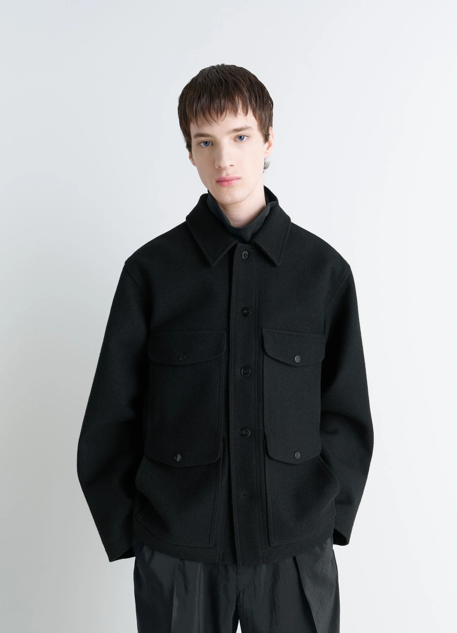 Lemaire utility jacket in black melton wool, model shot, front view pocketed, relaxed fit