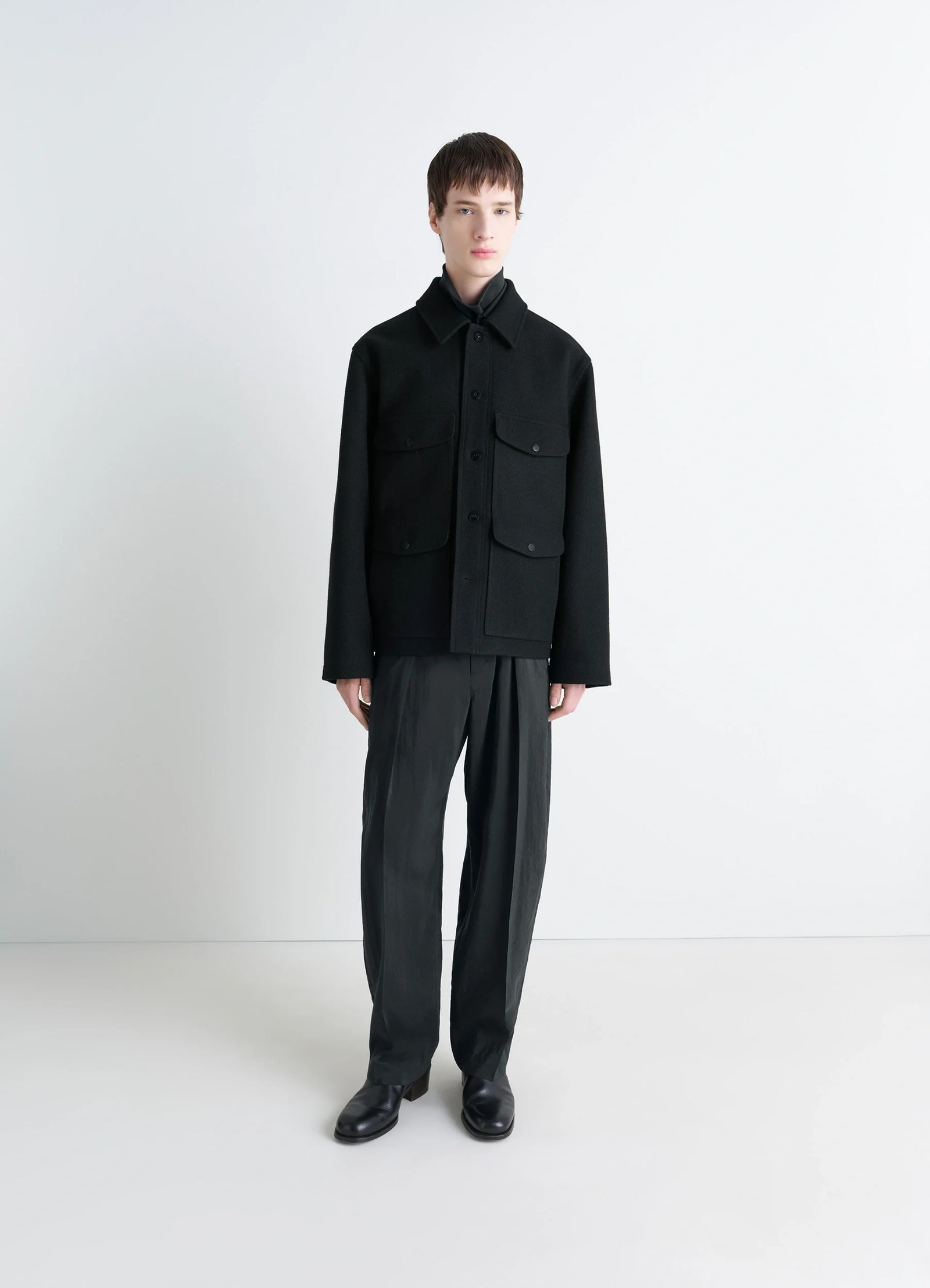 Lemaire utility jacket in black melton wool, model shot, three-quarter view buttoned with collar