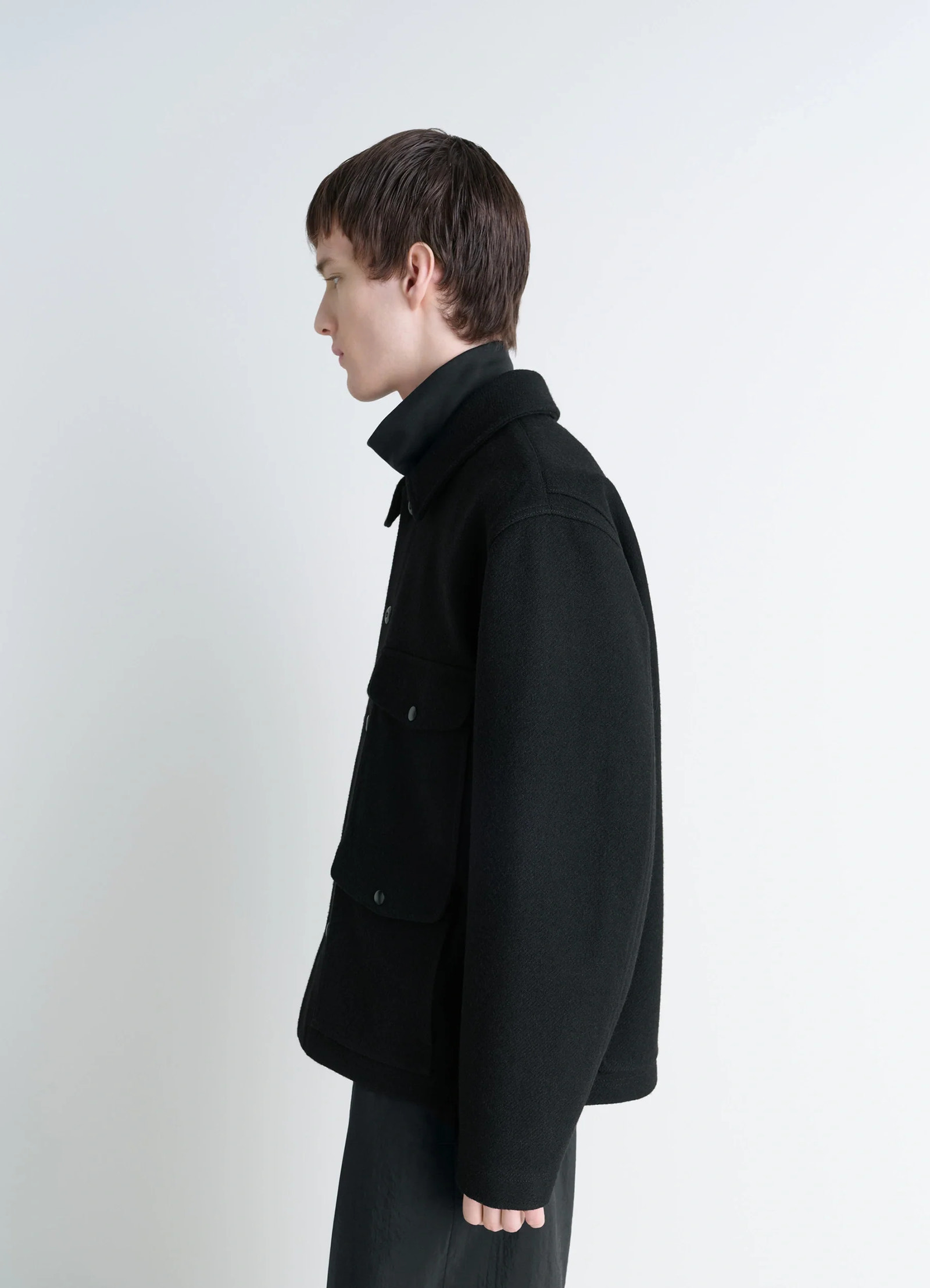 Lemaire utility jacket in black melton wool, model shot, side view high collar, dropped shoulders