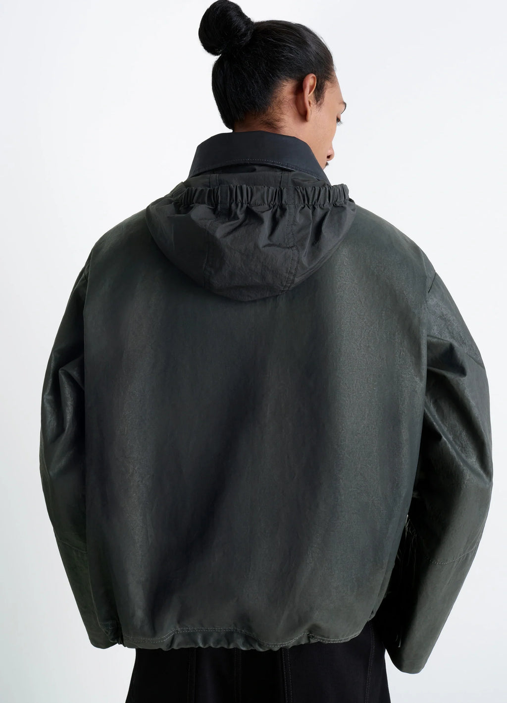 Short Rain Jacket in Resinated Cotton, model shot, over shoulder view hood detail, loose fit