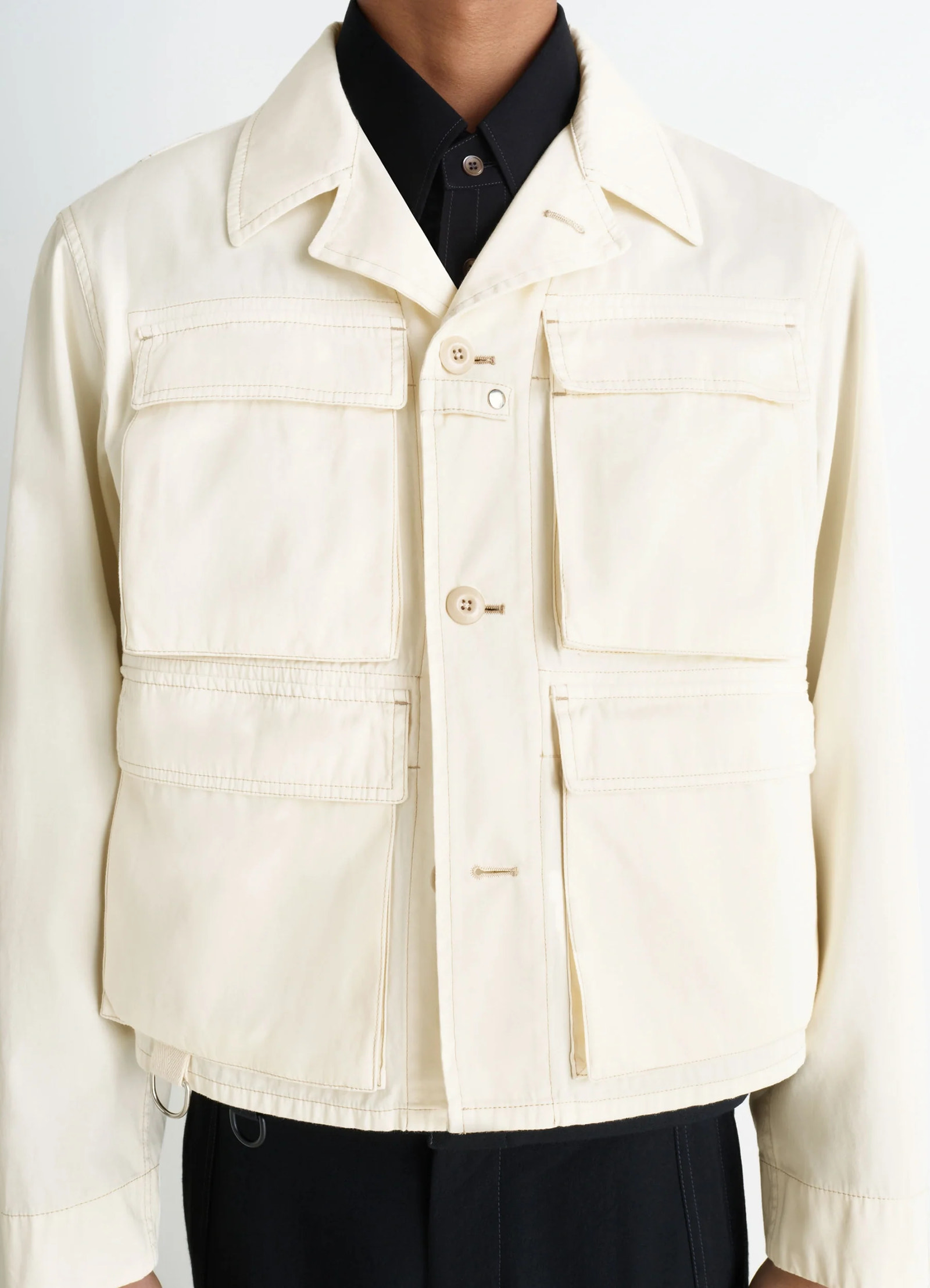 Short utility jacket in compact cotton twill, model shot, detail shot patina effect, d-rings