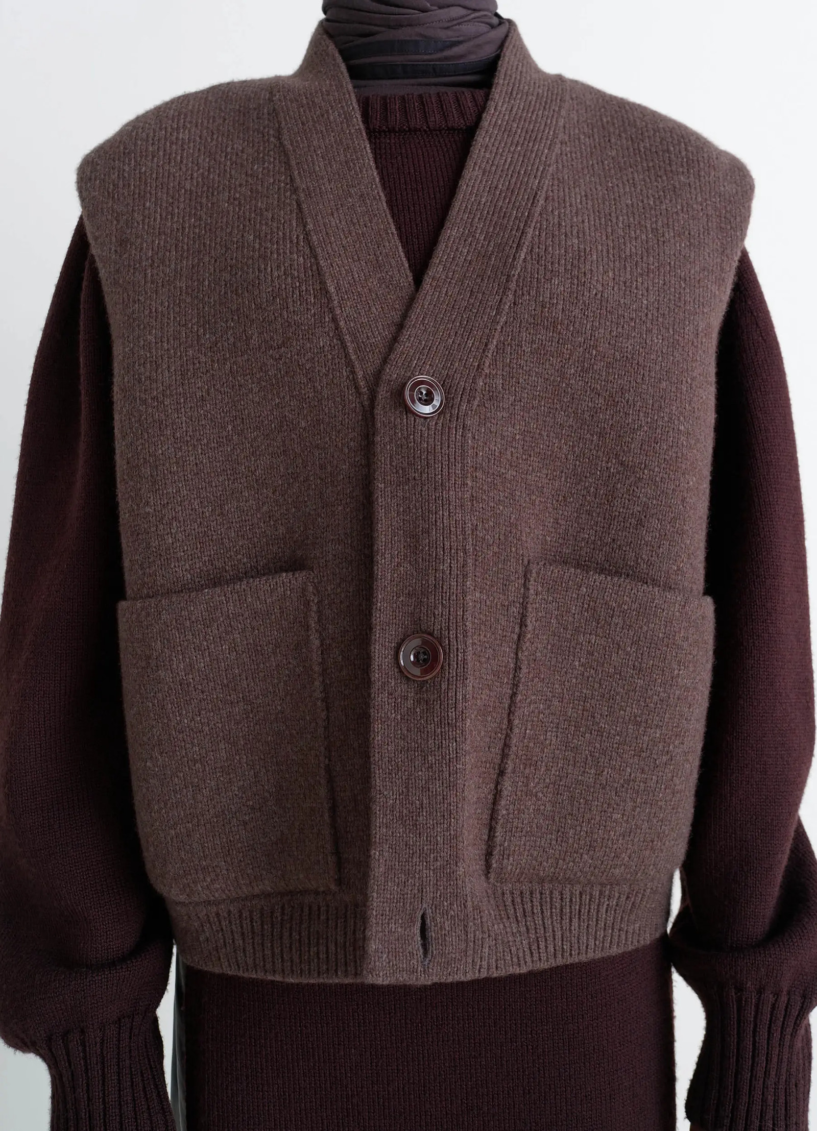 Maxi sleeveless cardigan in wool blend double-faced knit, model shot, close-up view ribbed hem, button detail