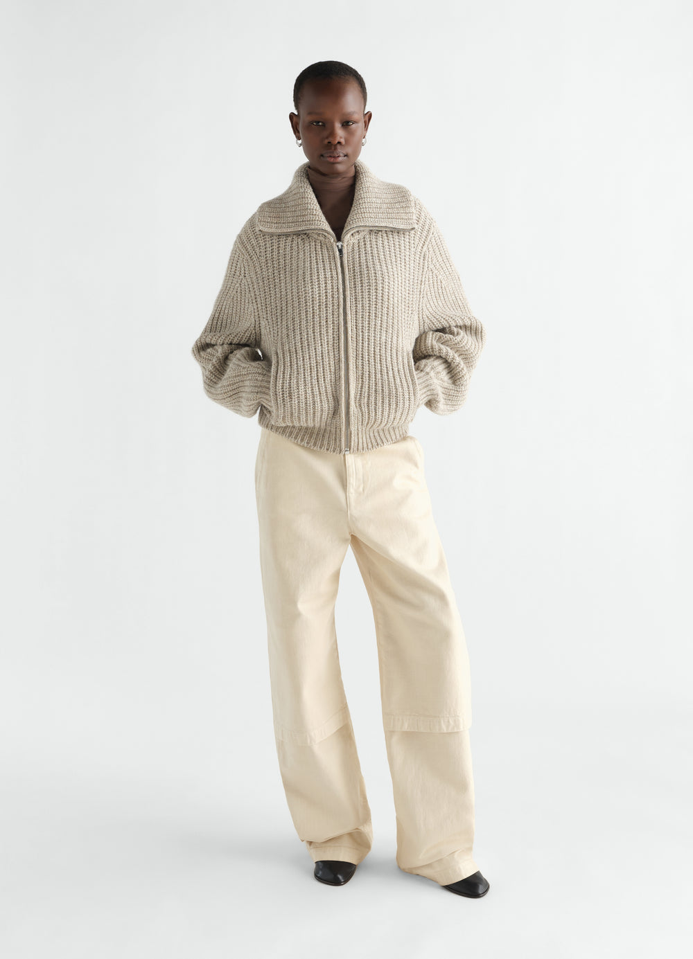 Cardigan zippé en laine alpaga et yak, coloris beige, porté par un mannequin, vue de face, fermeture zippée visible