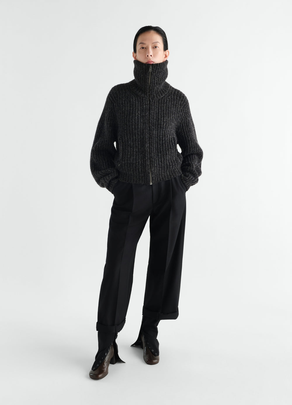 Zipped black yak alpaca cardigan by LEMAIRE worn by a model front view with high collar and long sleeves