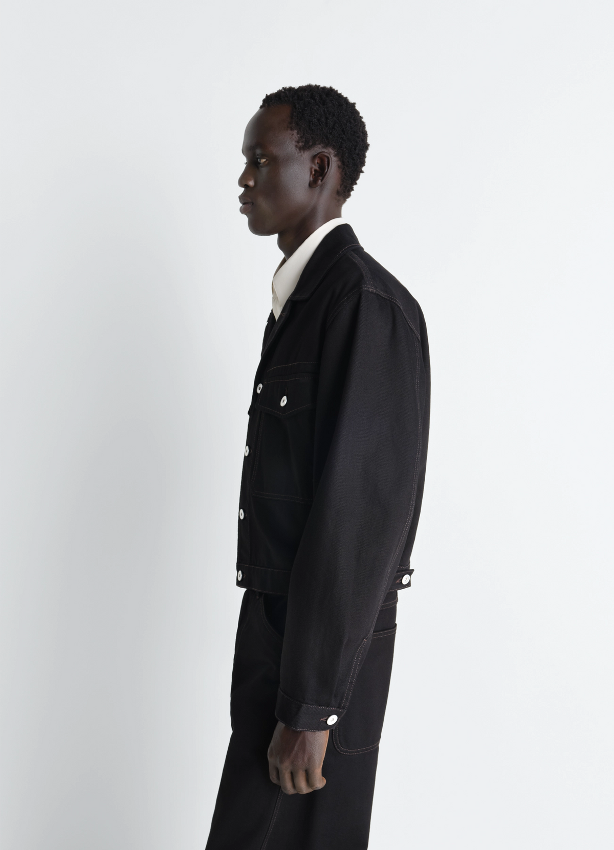 Lemaire Trucker Jacket in Deep Black Denim, model shot, Front view Fitted workwear style