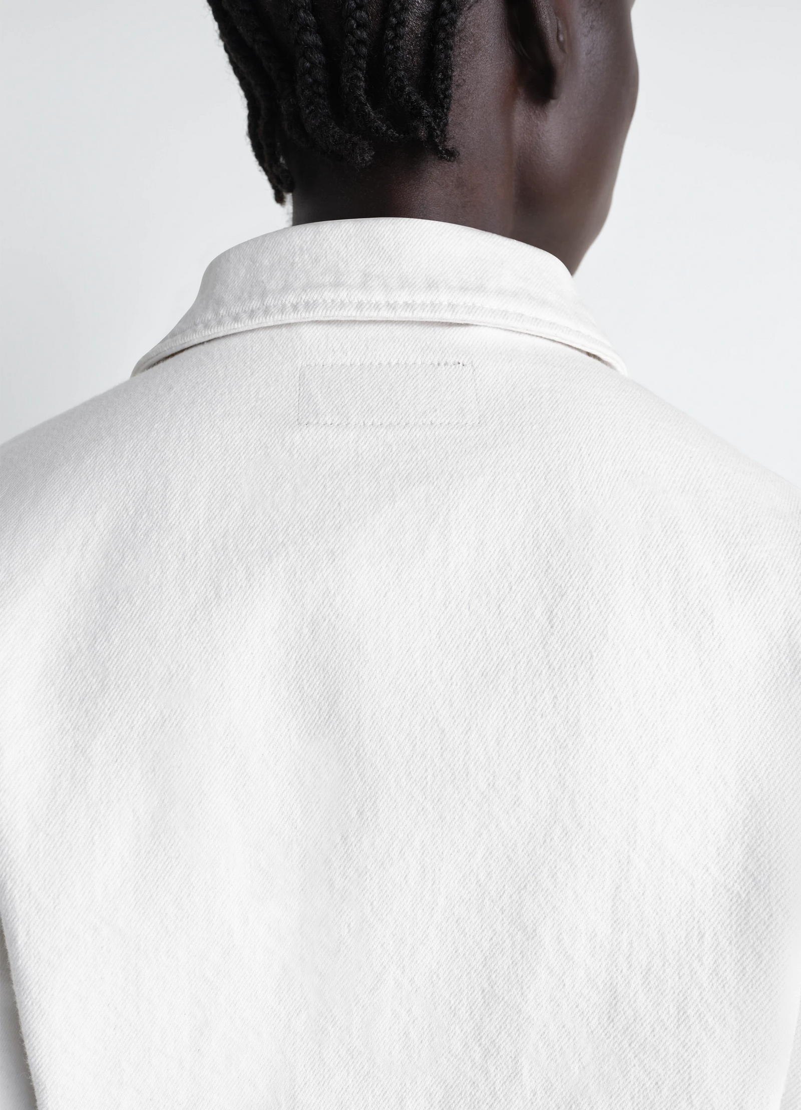 Cropped blouson in denim in bleached denim, model shot, back detail view collar stitching close-up