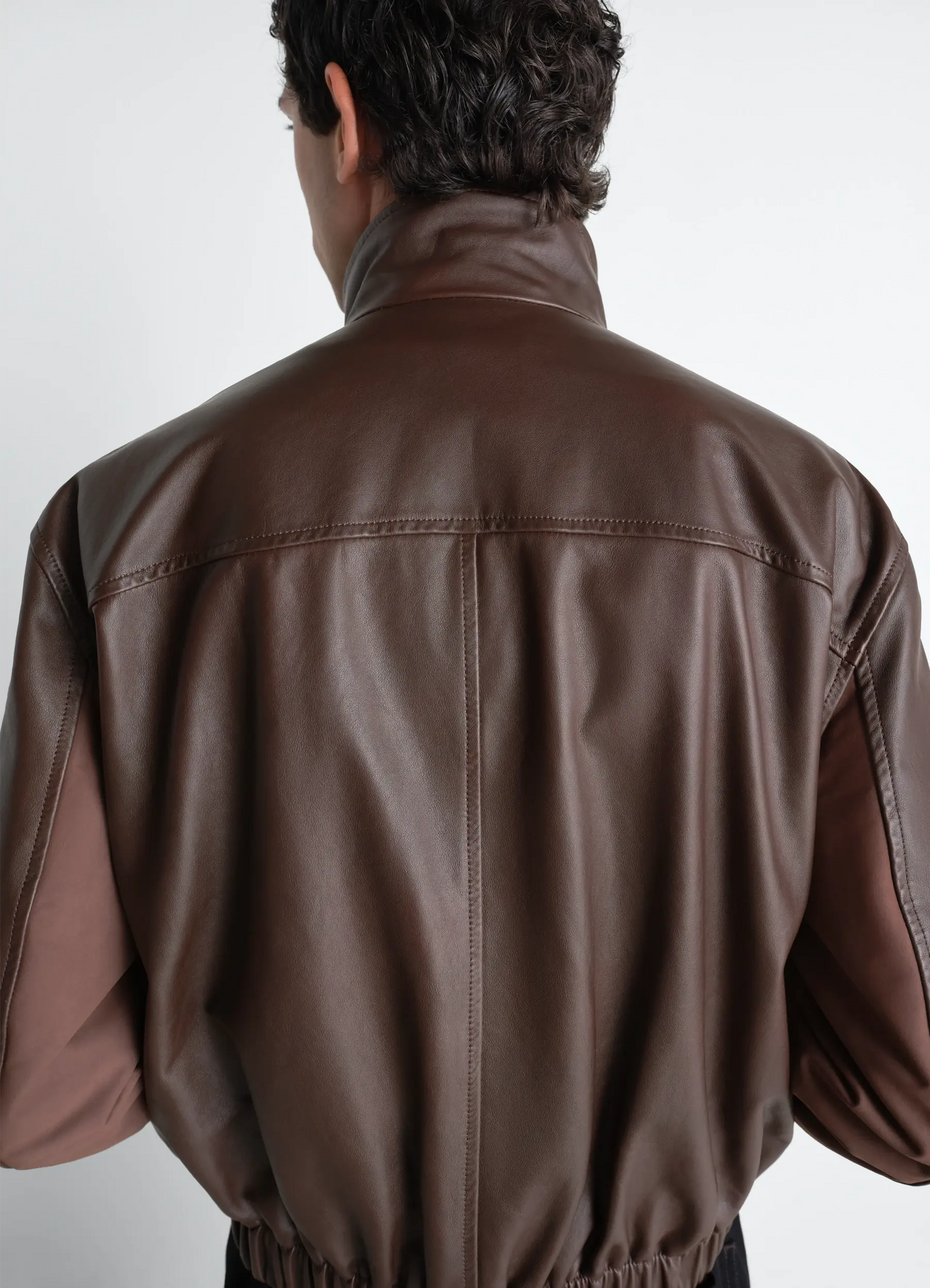 Lemaire soft leather blouson in paper leather, model shot, back view elastic hem detail view 8