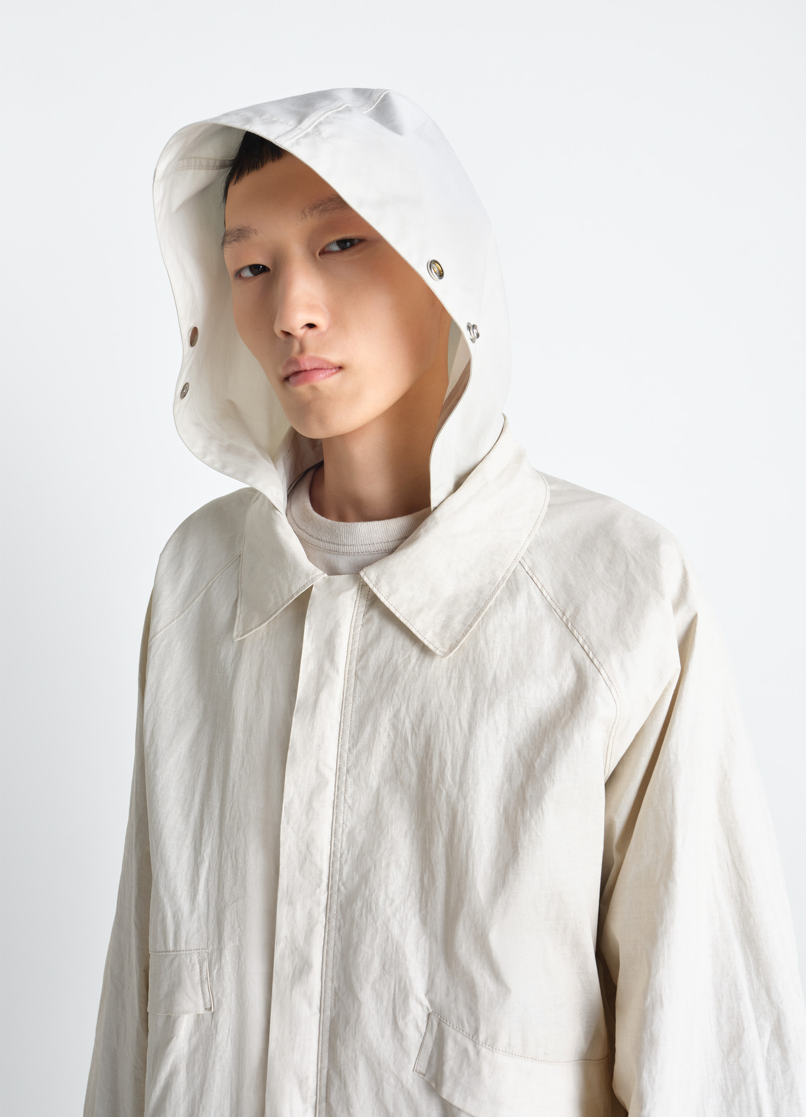 Lemaire rain jacket in coated technical linen, model shot, close-up side view hood detail focus