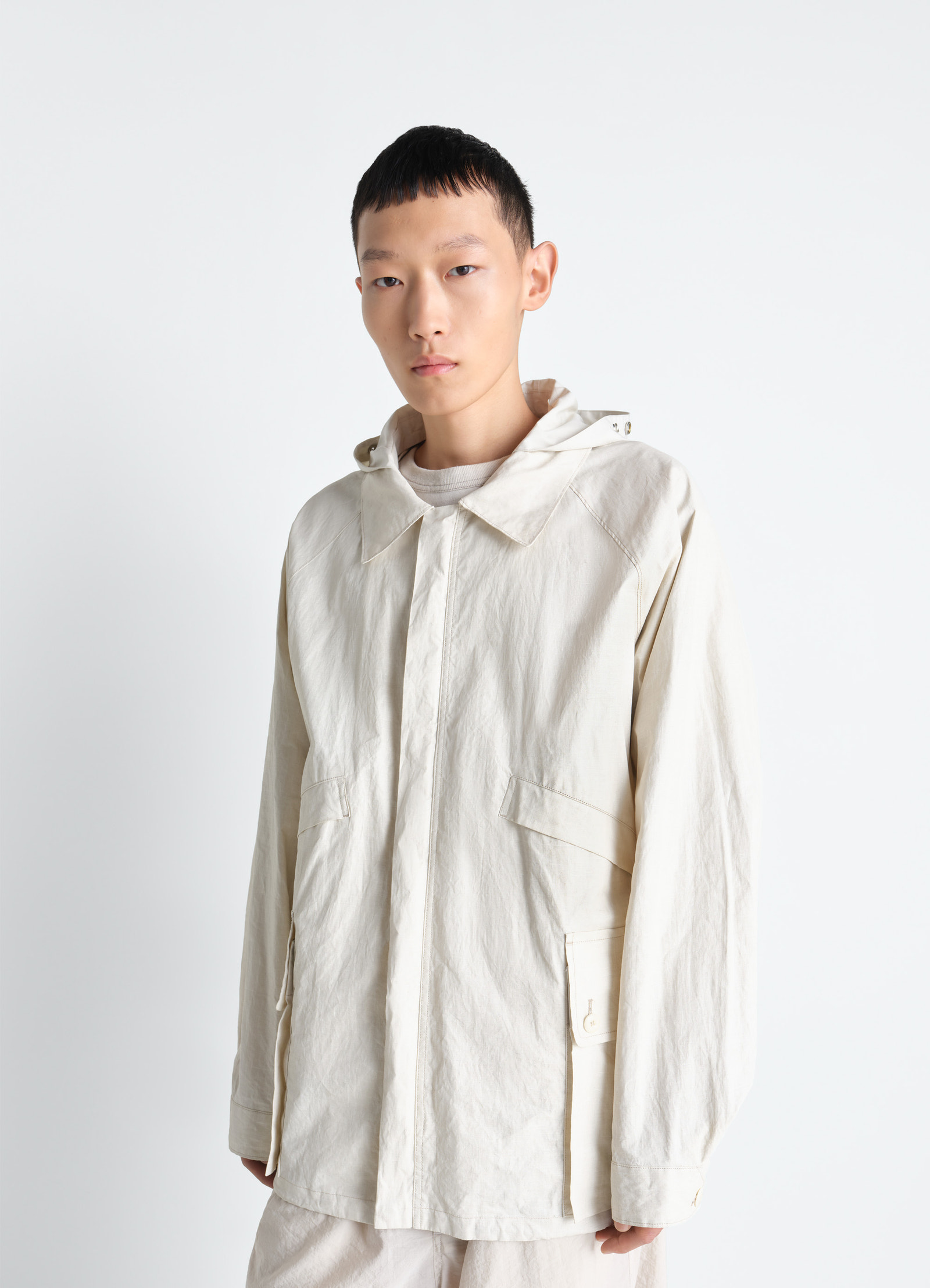 Lemaire rain jacket in coated technical linen, model shot, front view boxy volume, detachable hood